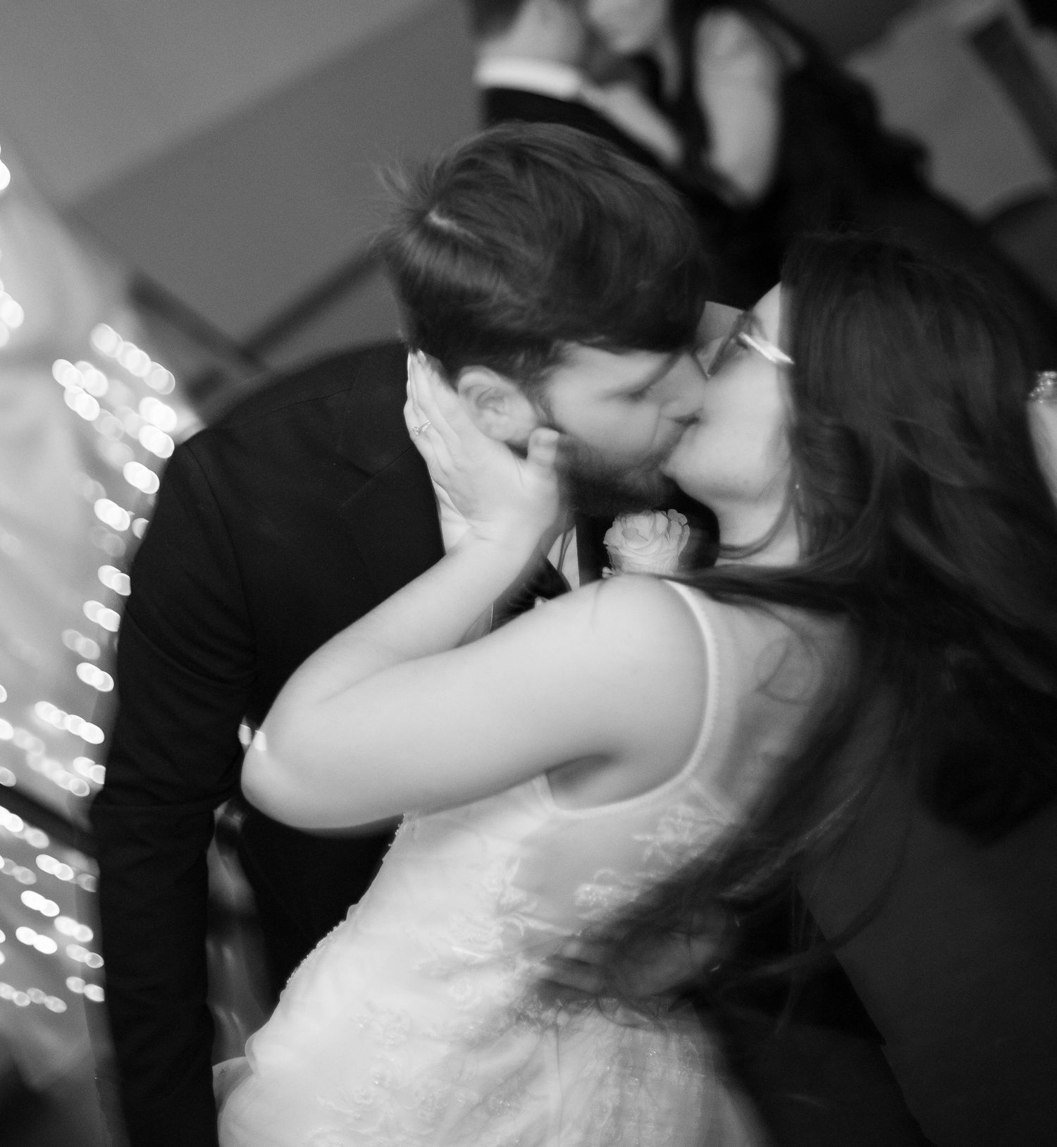 Black and white romantic sequence showing a couple sharing an intimate kiss in dramatic lighting.