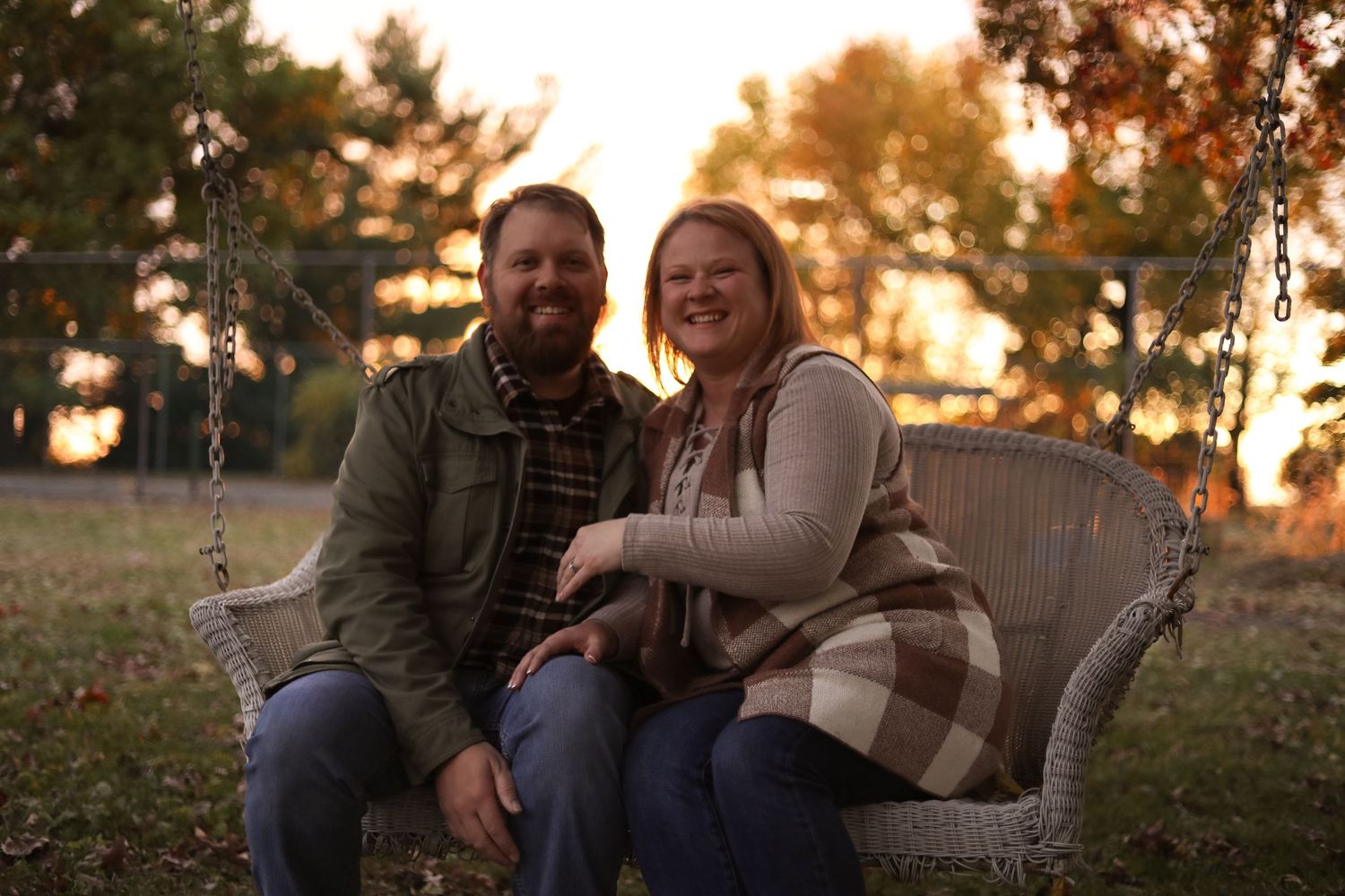 A couple relaxes together outdoors during golden hour sunset.