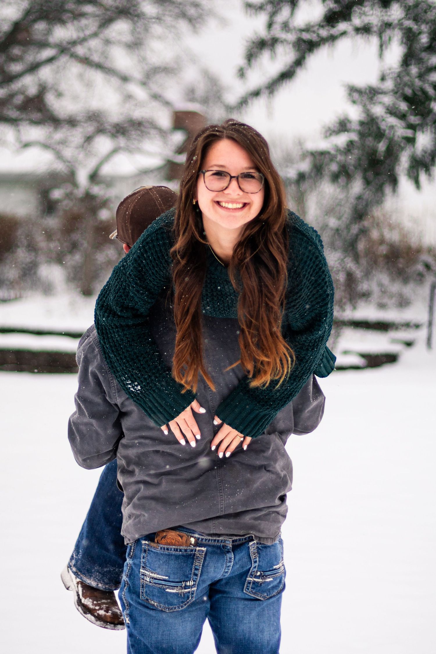 Playful piggyback ride moment captured in a snowy winter setting.