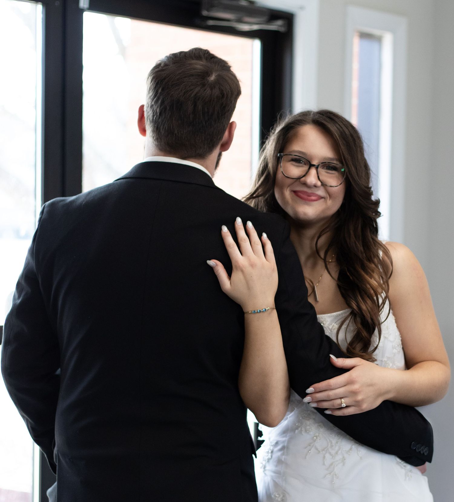 A couple in formal attire sharing an intimate embrace during what appears to be a wedding celebration.