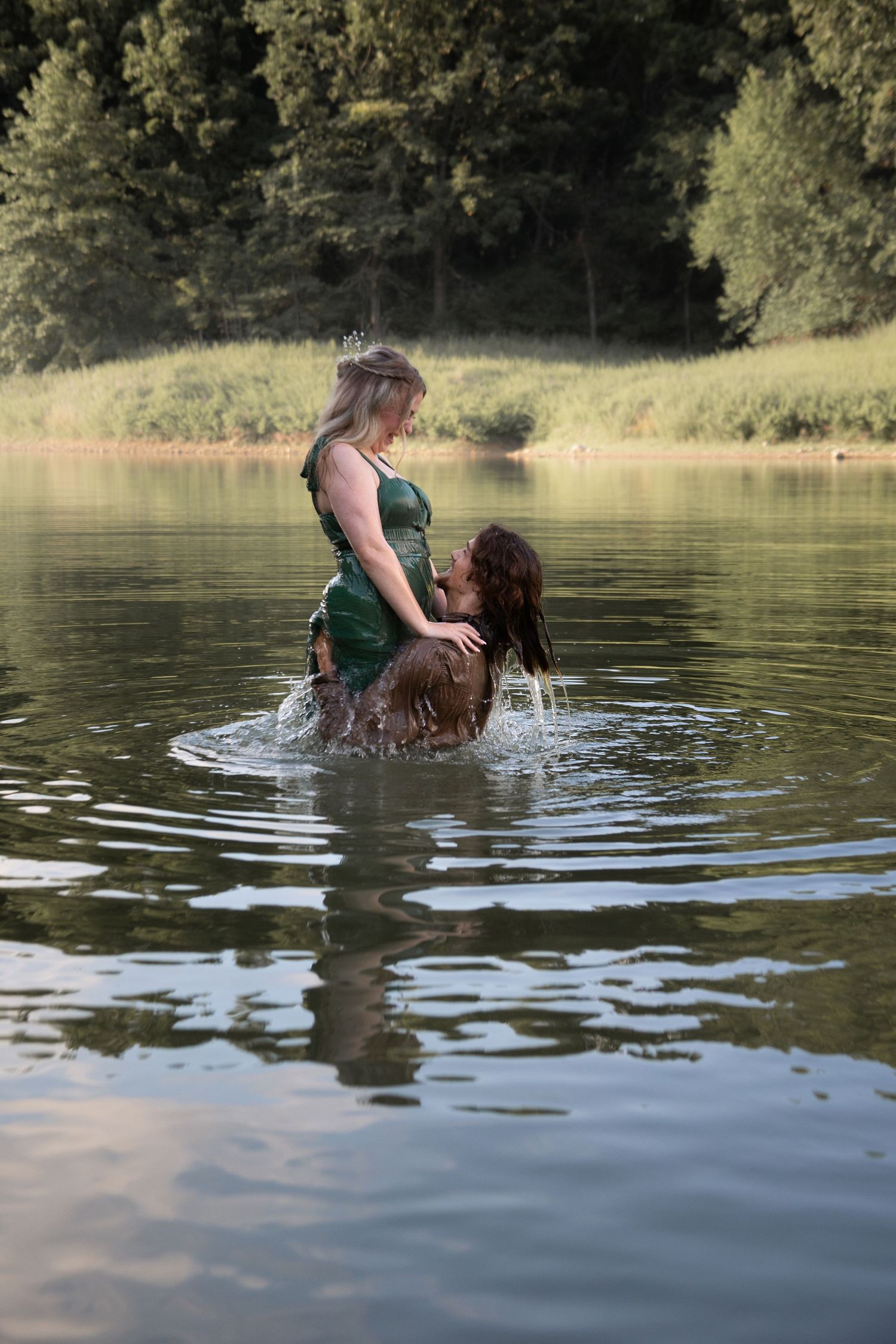 Two people sharing intimate moment while wading in peaceful lake waters.