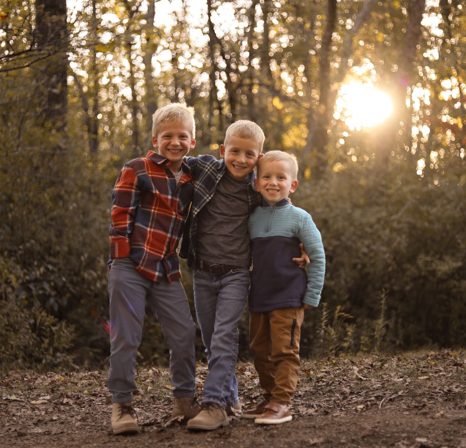 Children's feet and legs shown from the knees down standing together outdoors at sunset.