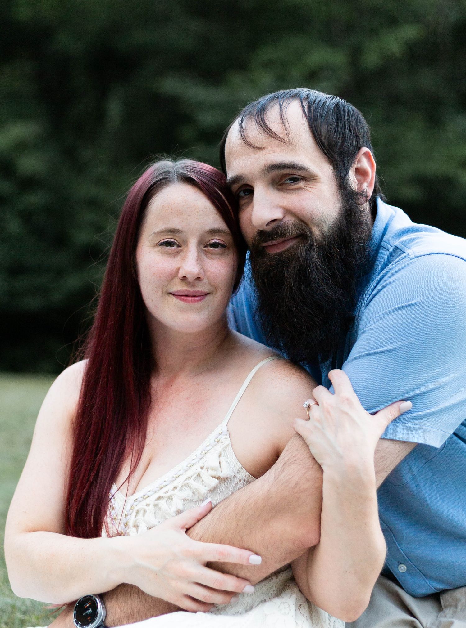 A couple shares a tender embrace outdoors during a romantic photoshoot.