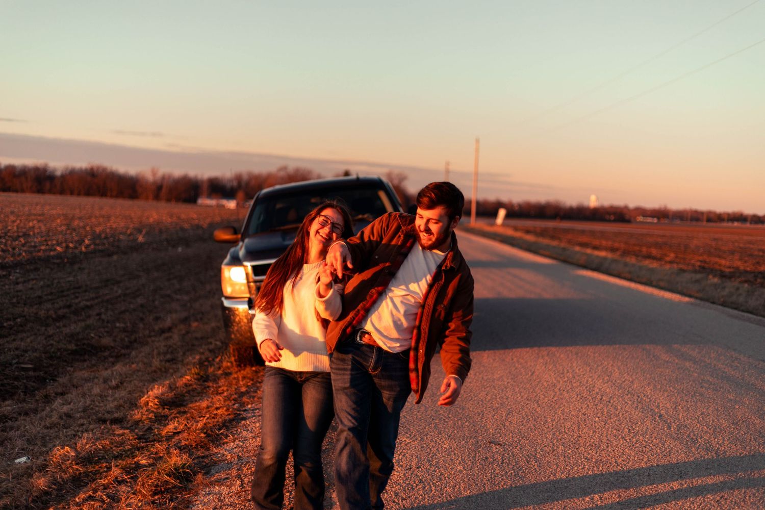 Sunset silhouette photos of people walking together on a rural road.