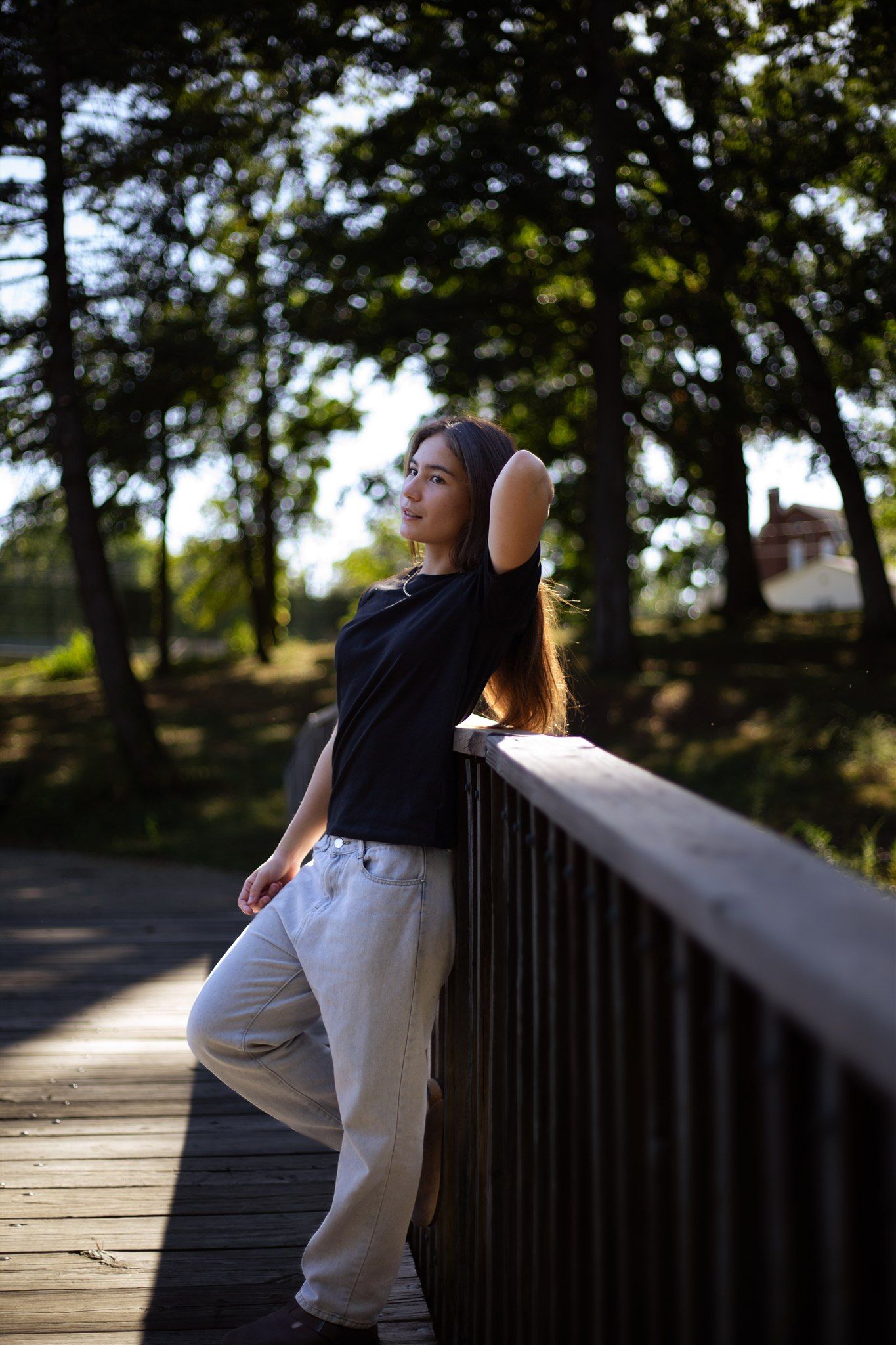 Person in athletic wear stretches and poses against a railing during golden hour.