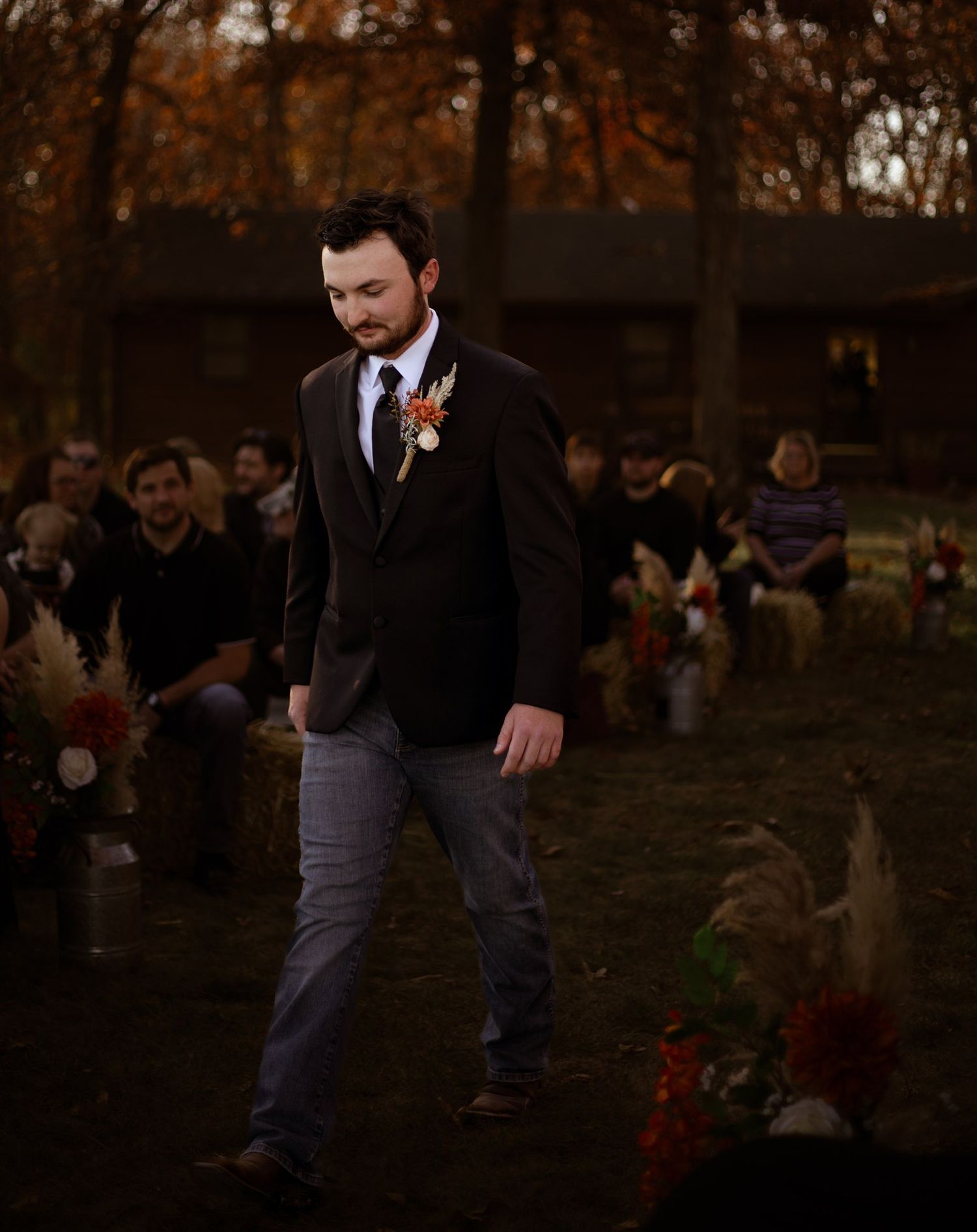 Wedding party members in dark attire celebrating at outdoor autumn reception.