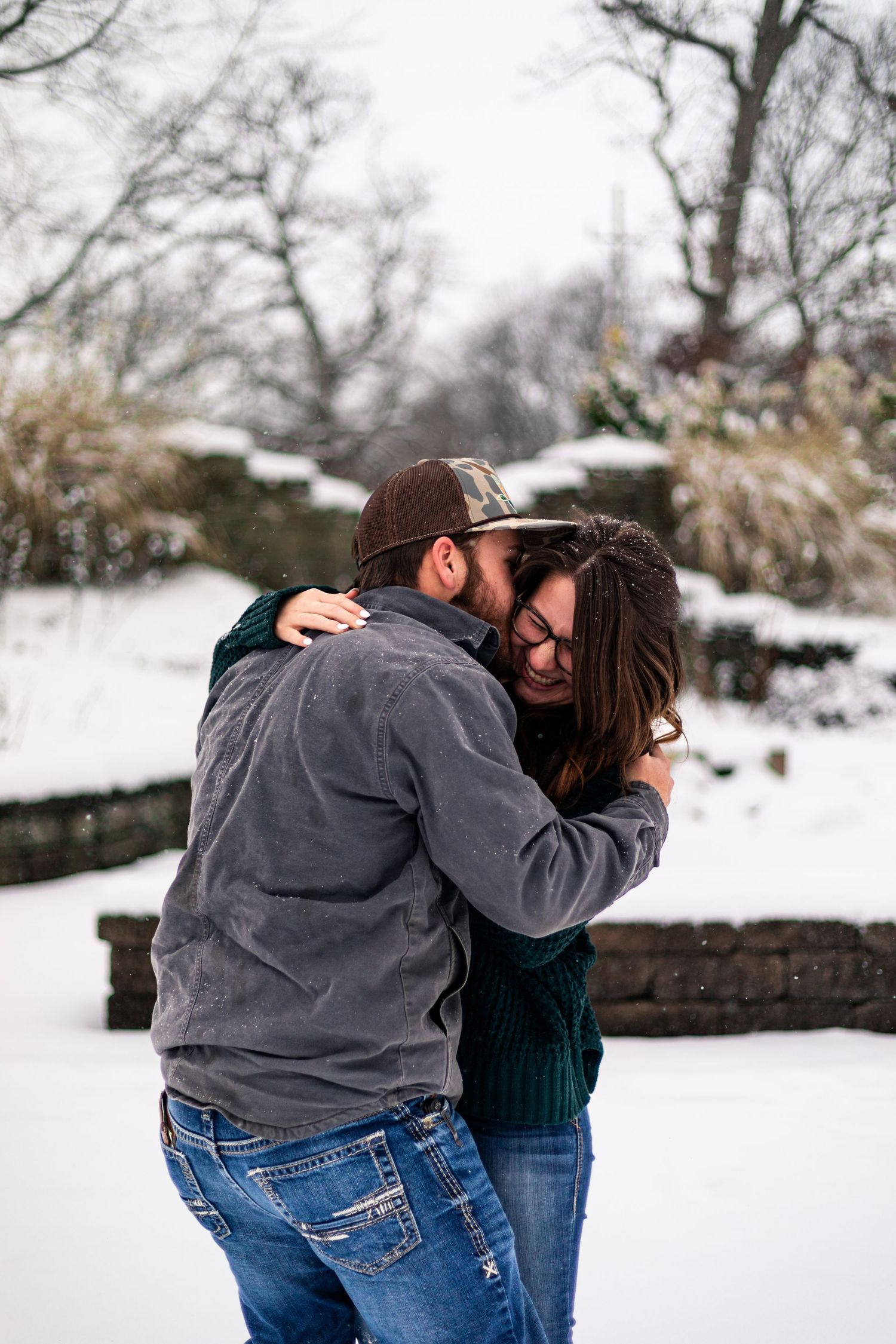 Couple sharing an intimate embrace while standing in fresh snow.