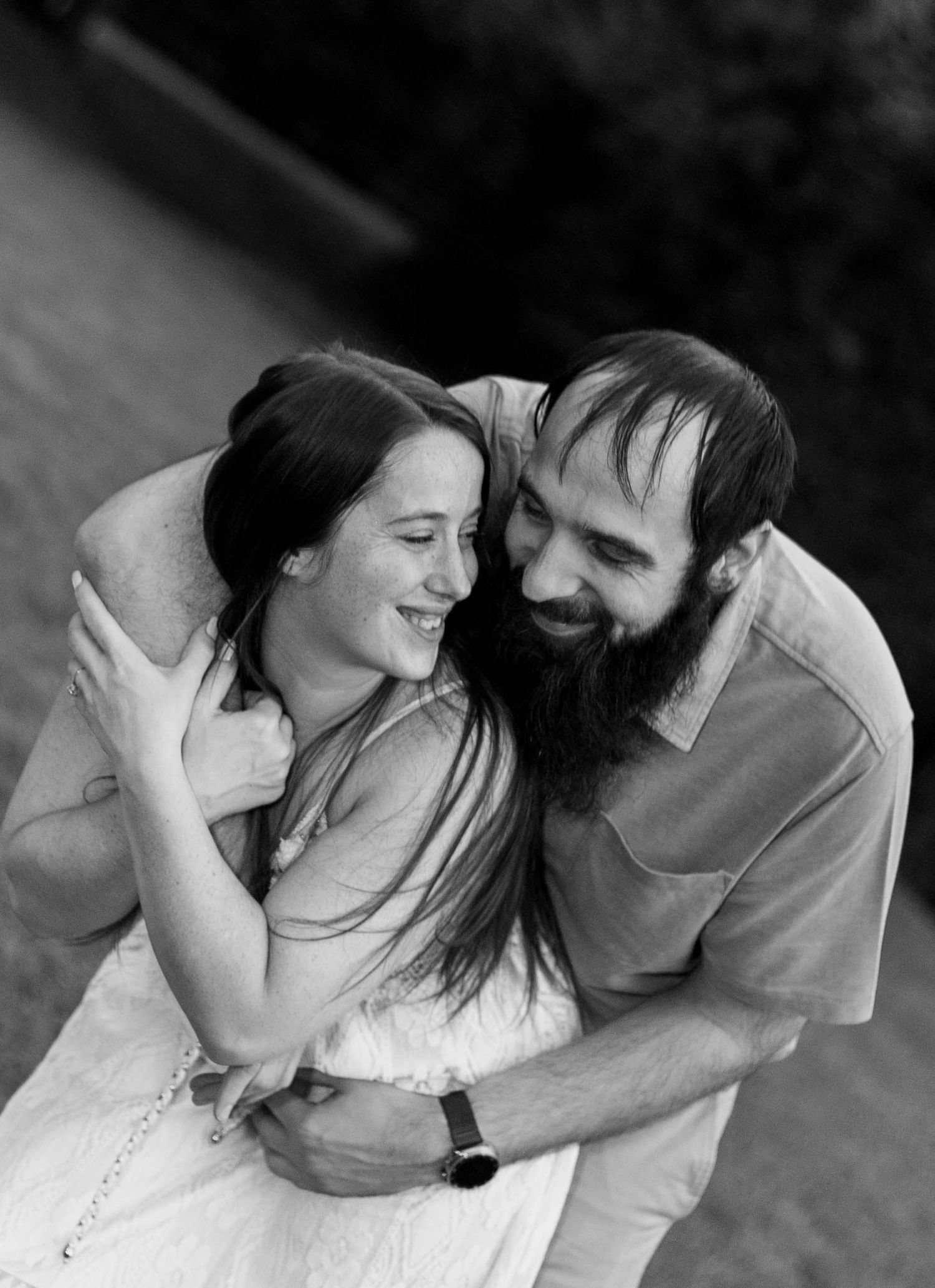 A romantic black and white portrait of a couple embracing.