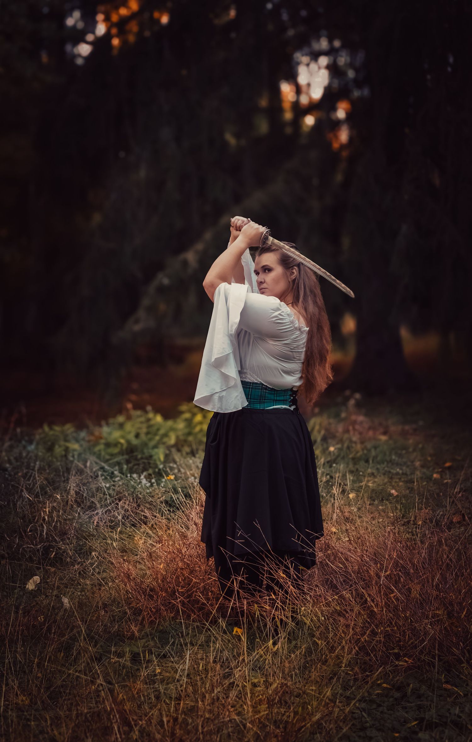 A person in a white top and black skirt holds a sword in a moody autumn forest setting at dusk.