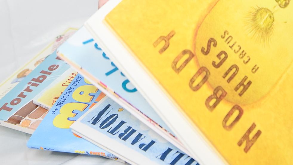 Stack of colorful children's picture books fanned out on a white background.