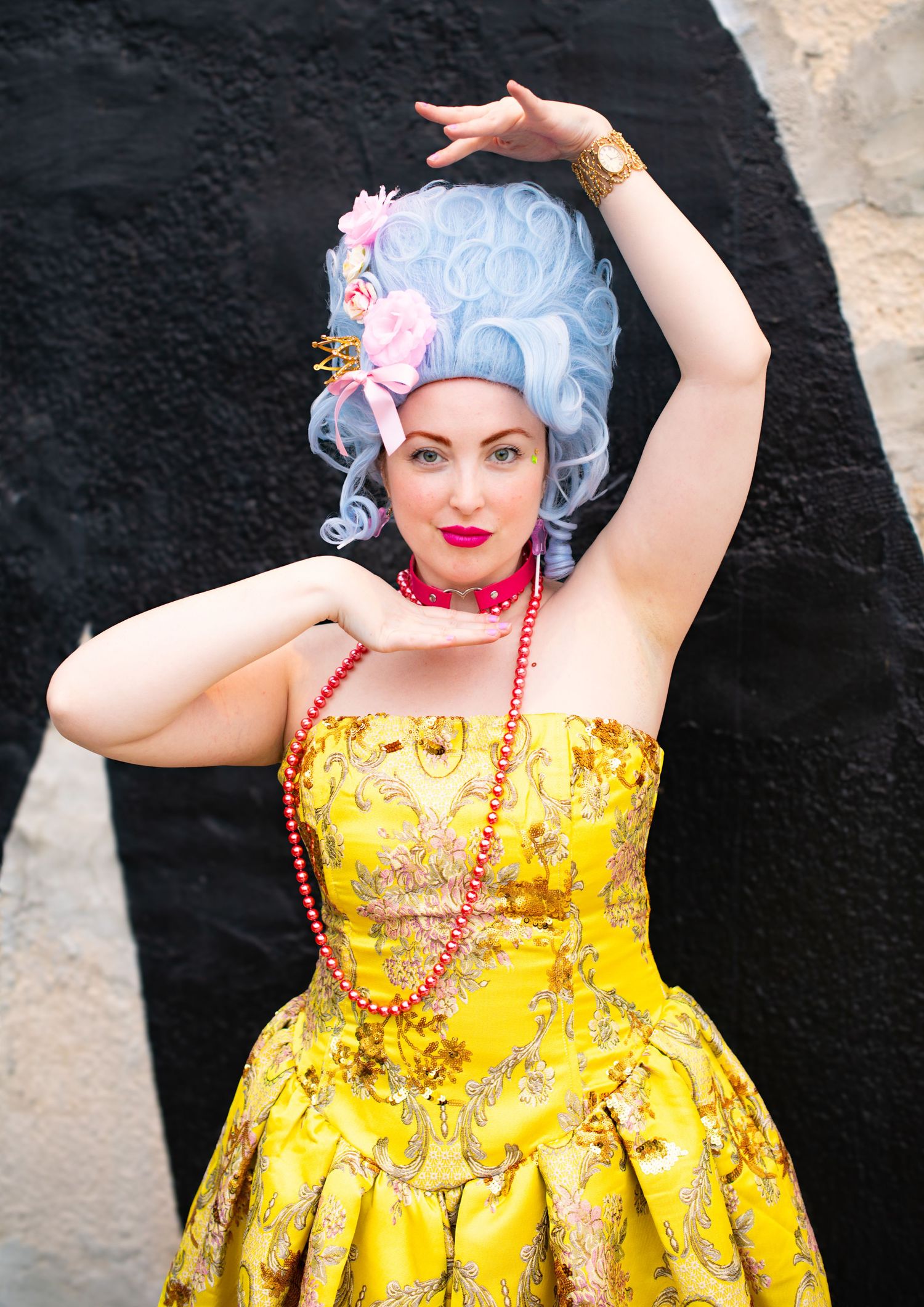Woman in antique-inspired yellow dress with blue wig strikes vogue pose in professional portrait. Baltimore, MD.