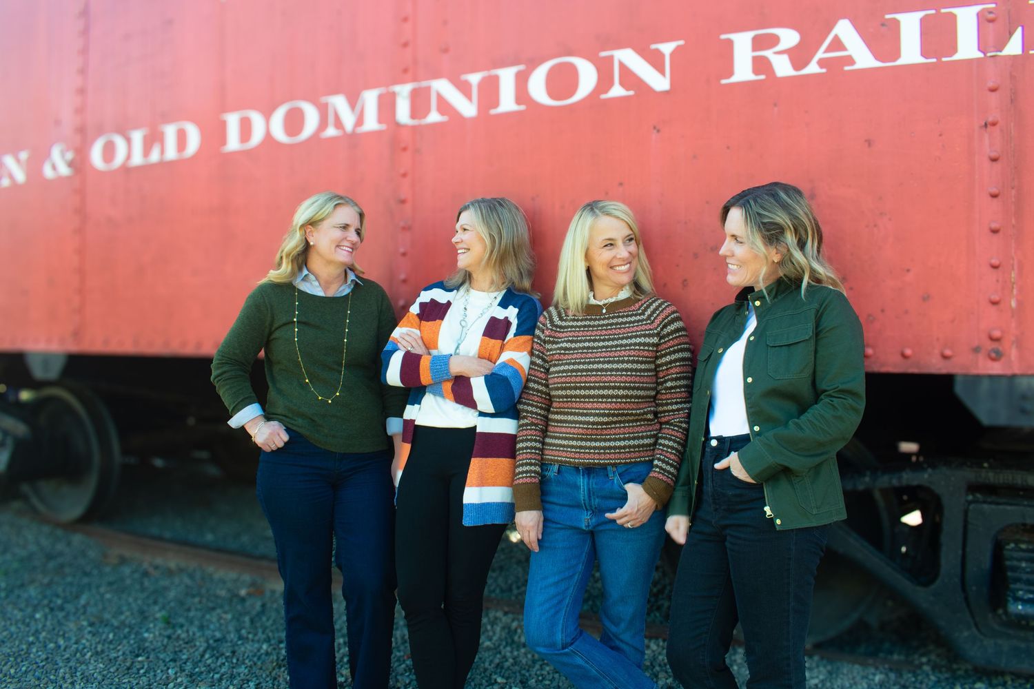Friends gathered by vintage red Norfolk & Old Dominion railway car for outdoor photos.