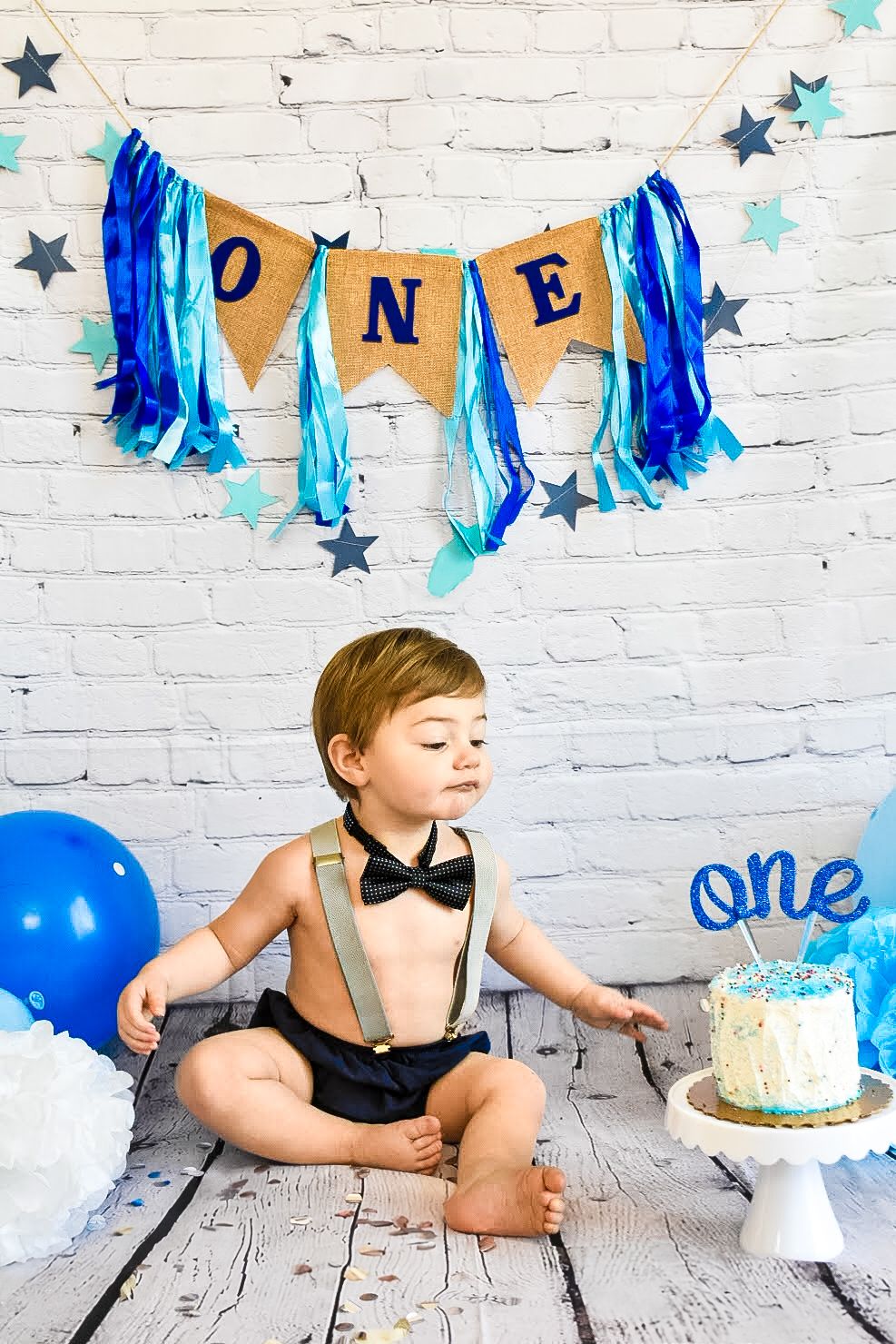 Cake smash photo session promotional banner with blue decorative elements.