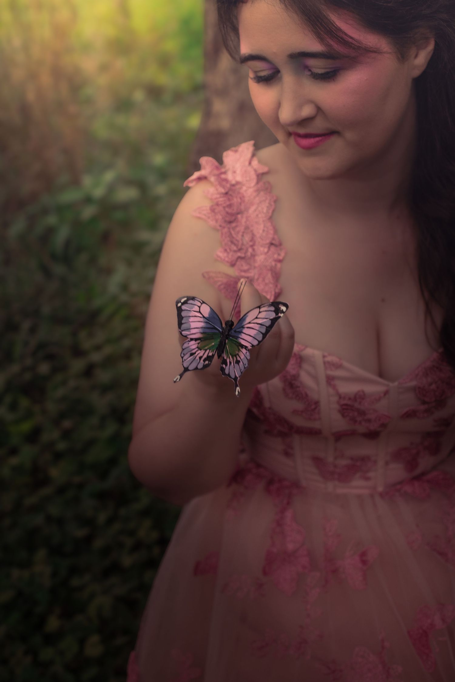Enchanted forest photography with pink dress and decorative butterfly accents.