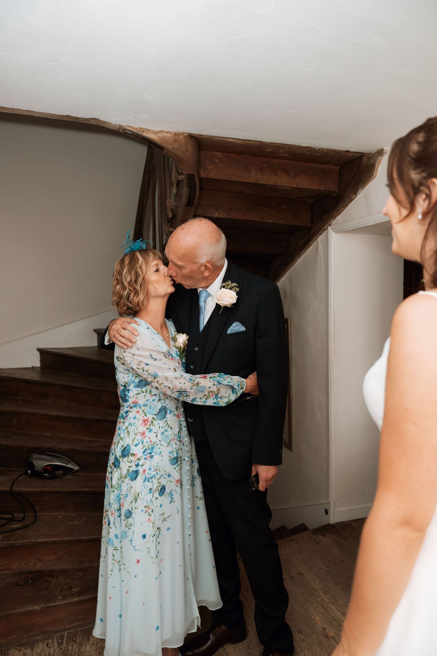 Emotional first look sequence showing couple embracing in an indoor setting with rustic wooden beams and white walls.