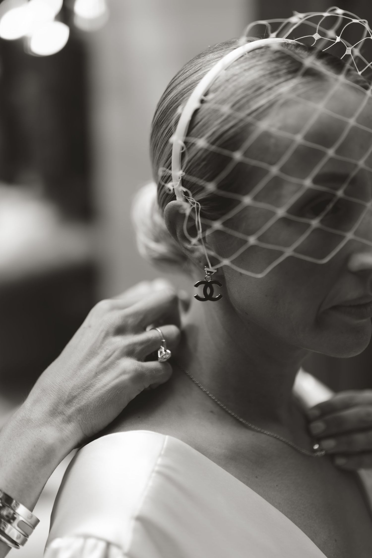 Black and white profile shots show a person wearing a netted veil and Chanel earring wiping away tears.