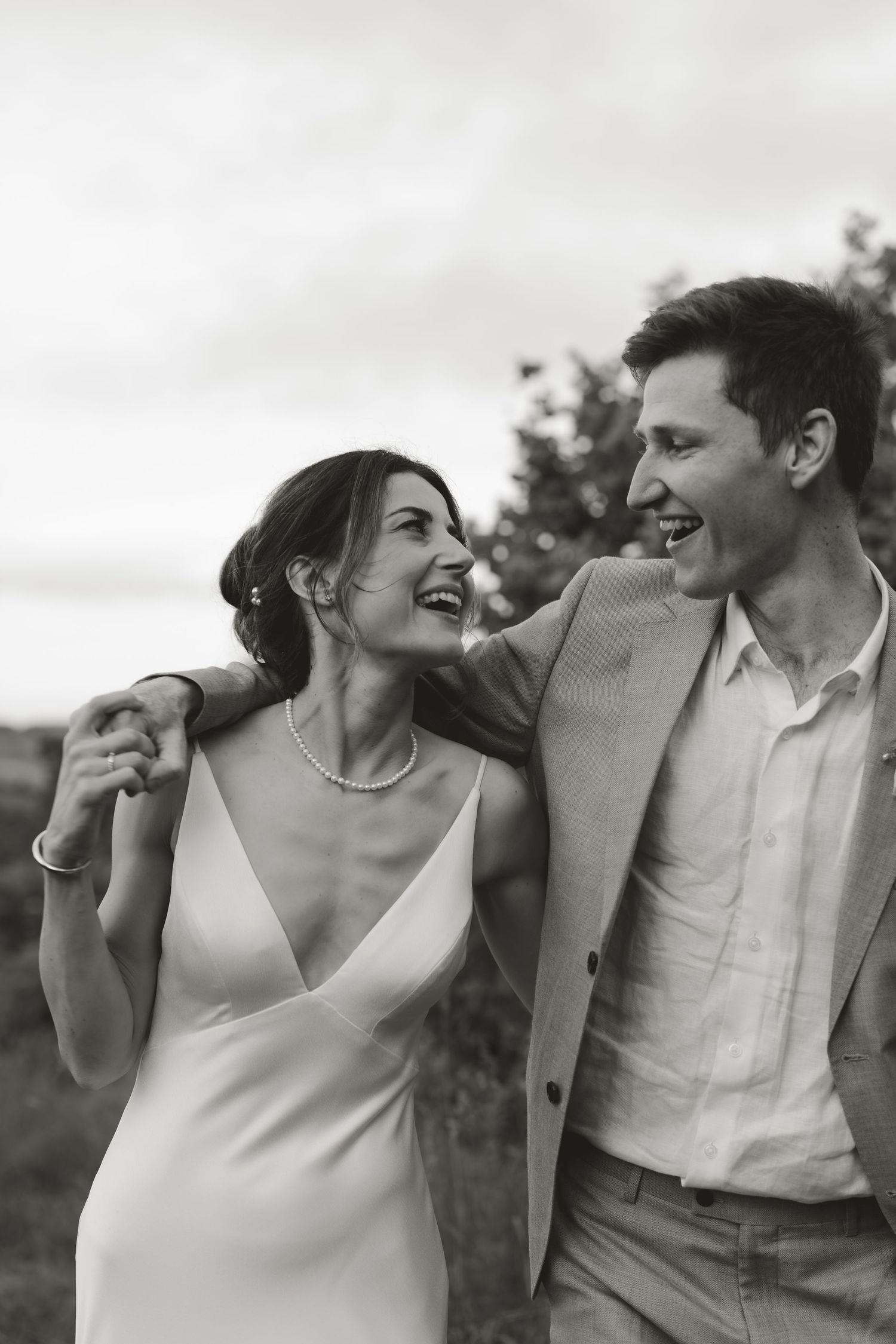 Black and white outdoor wedding portraits showing candid laughter and joy.