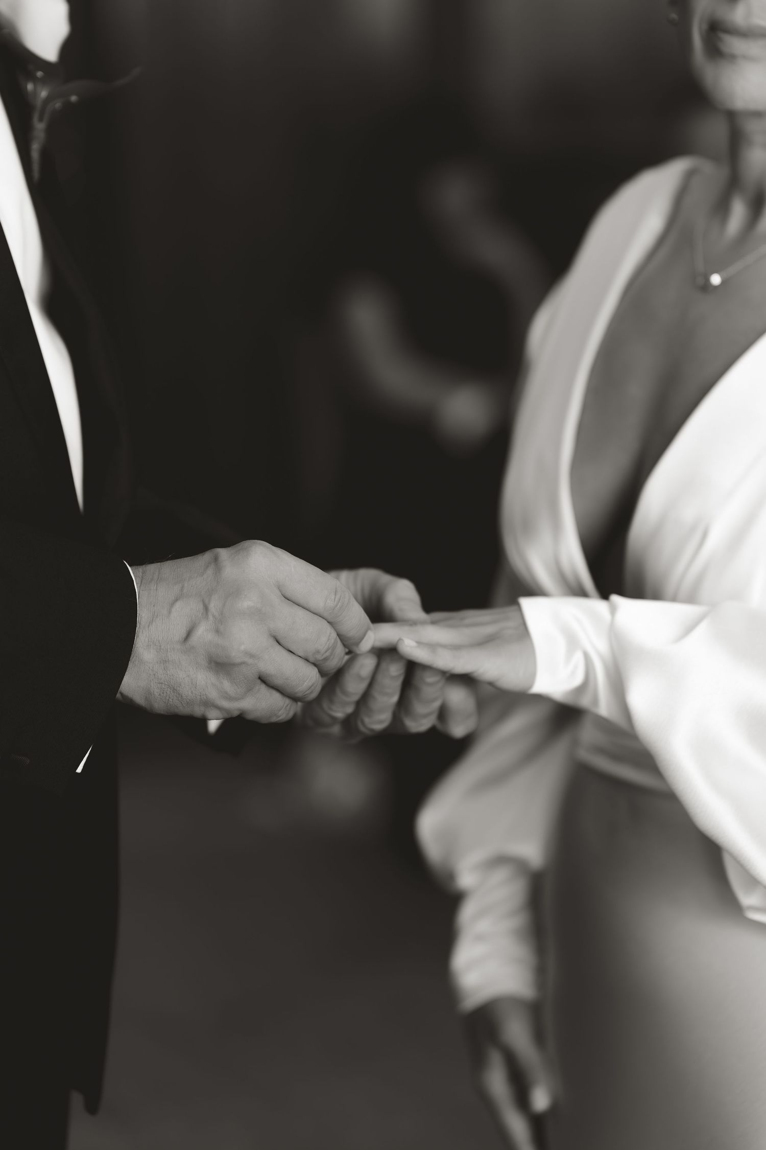 Close-up of hands exchanging wedding rings during a ceremony.
