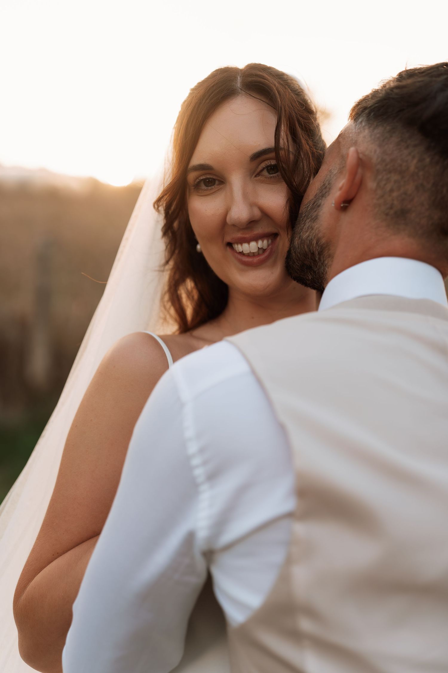 A romantic sunset moment captured between newlyweds during their wedding photoshoot.