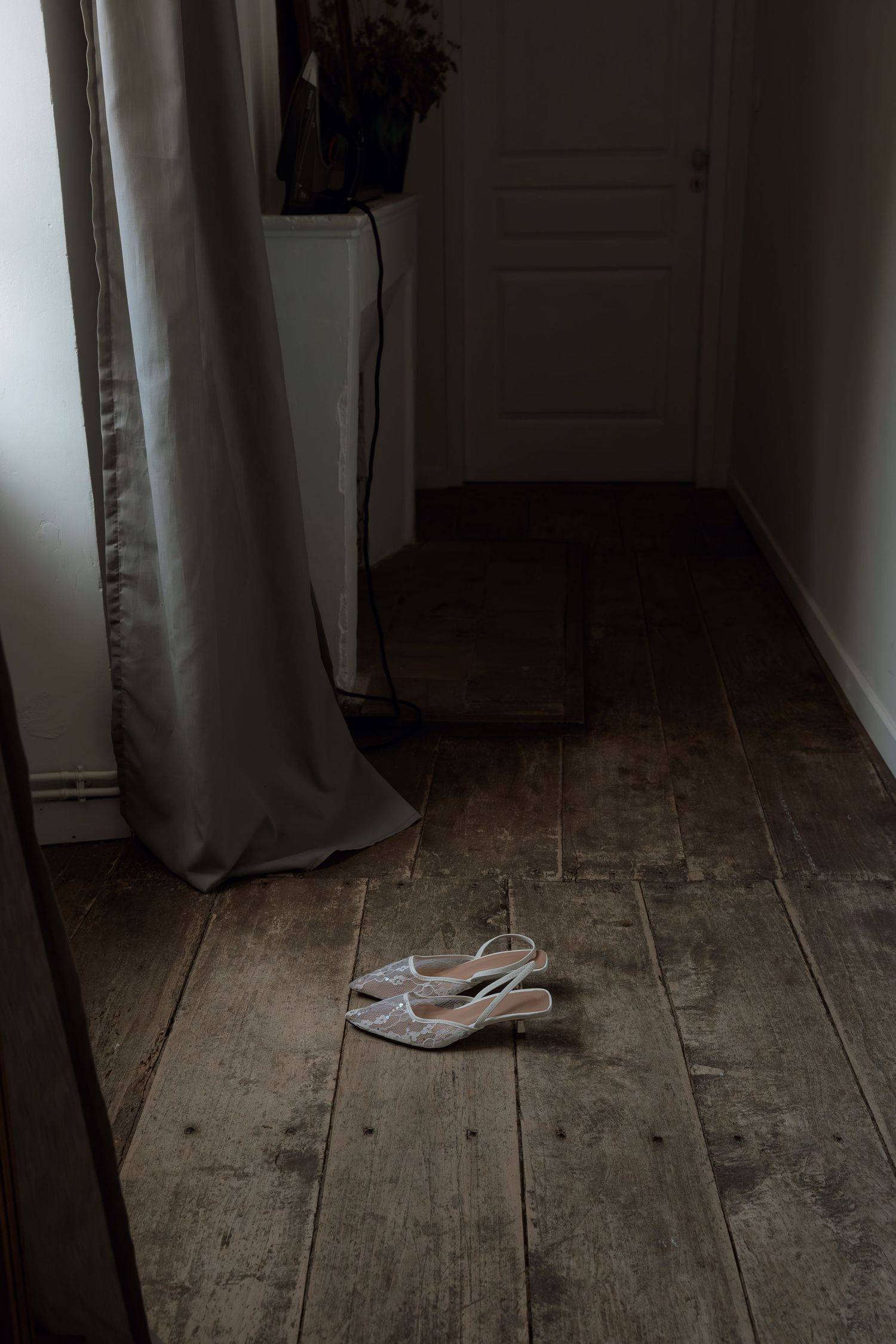 A series of five photos showing a single high heel shoe on a rustic wooden floor in dim lighting.