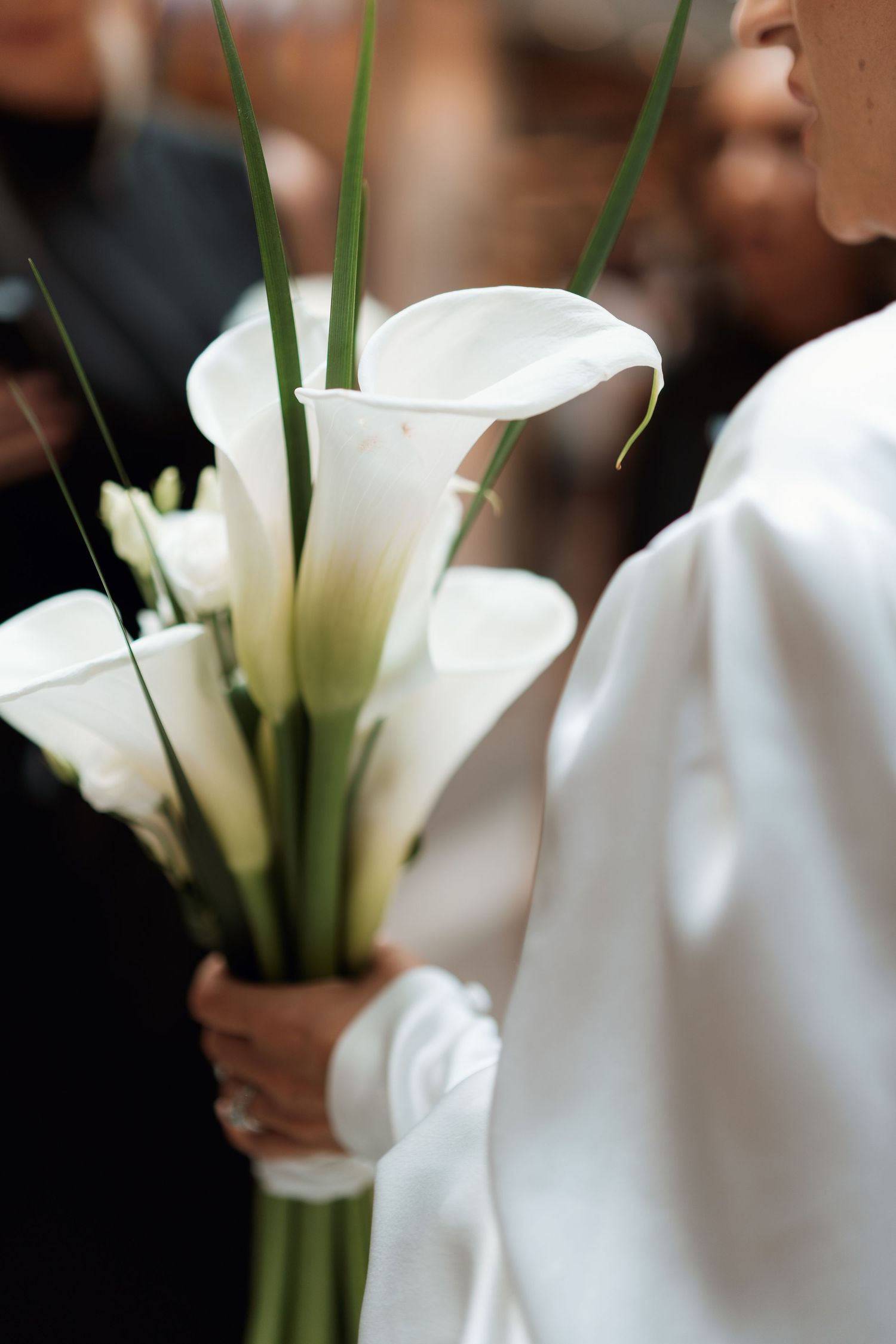 White calla lilies in elegant wedding bouquets against a dark background.