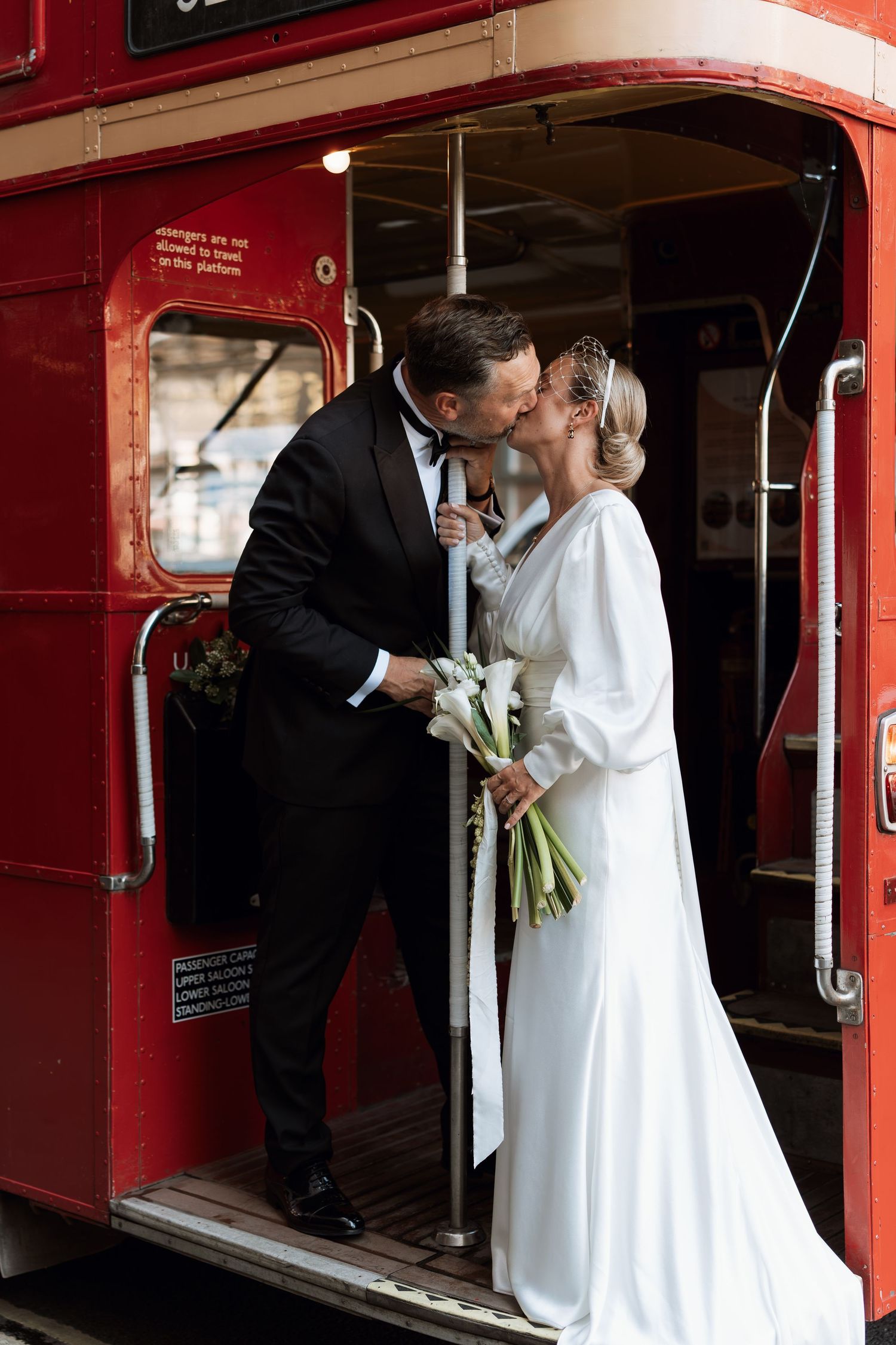 Wedding couple sharing an intimate moment inside a vintage red train car.