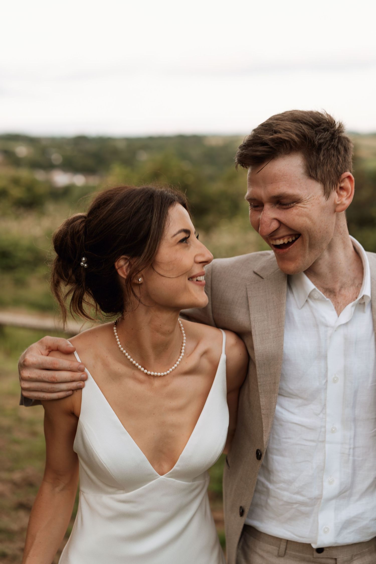 Romantic couple in wedding attire sharing intimate moments against a scenic outdoor backdrop.