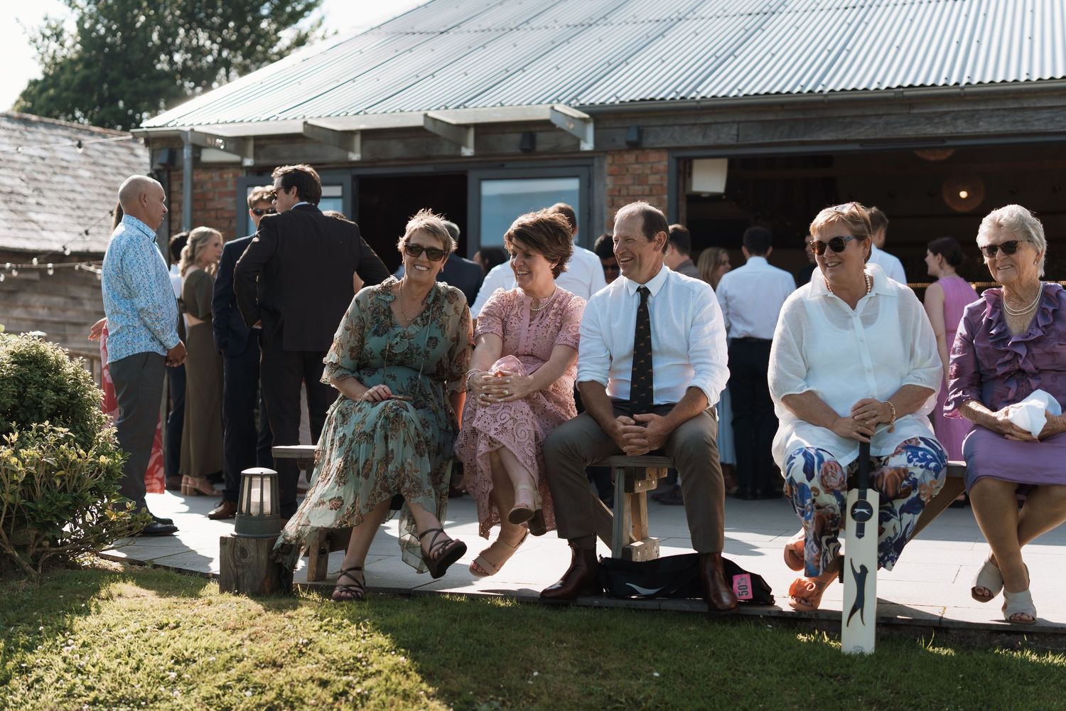 People gathered at an outdoor venue with a metal roof visible in the background.
