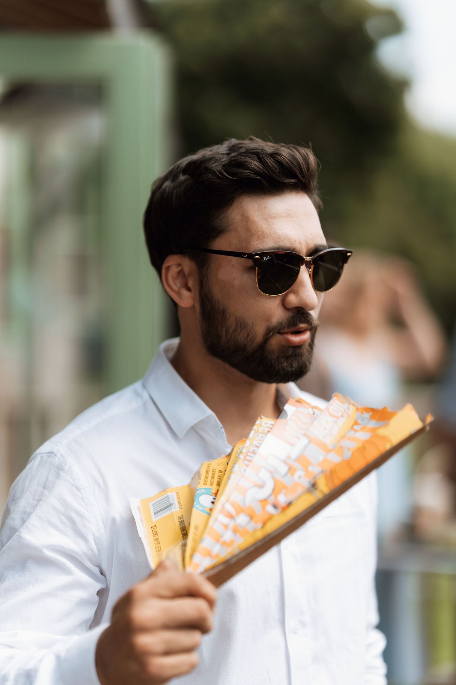 Person in sunglasses and white shirt holding orange tickets in a sequence of outdoor photos.