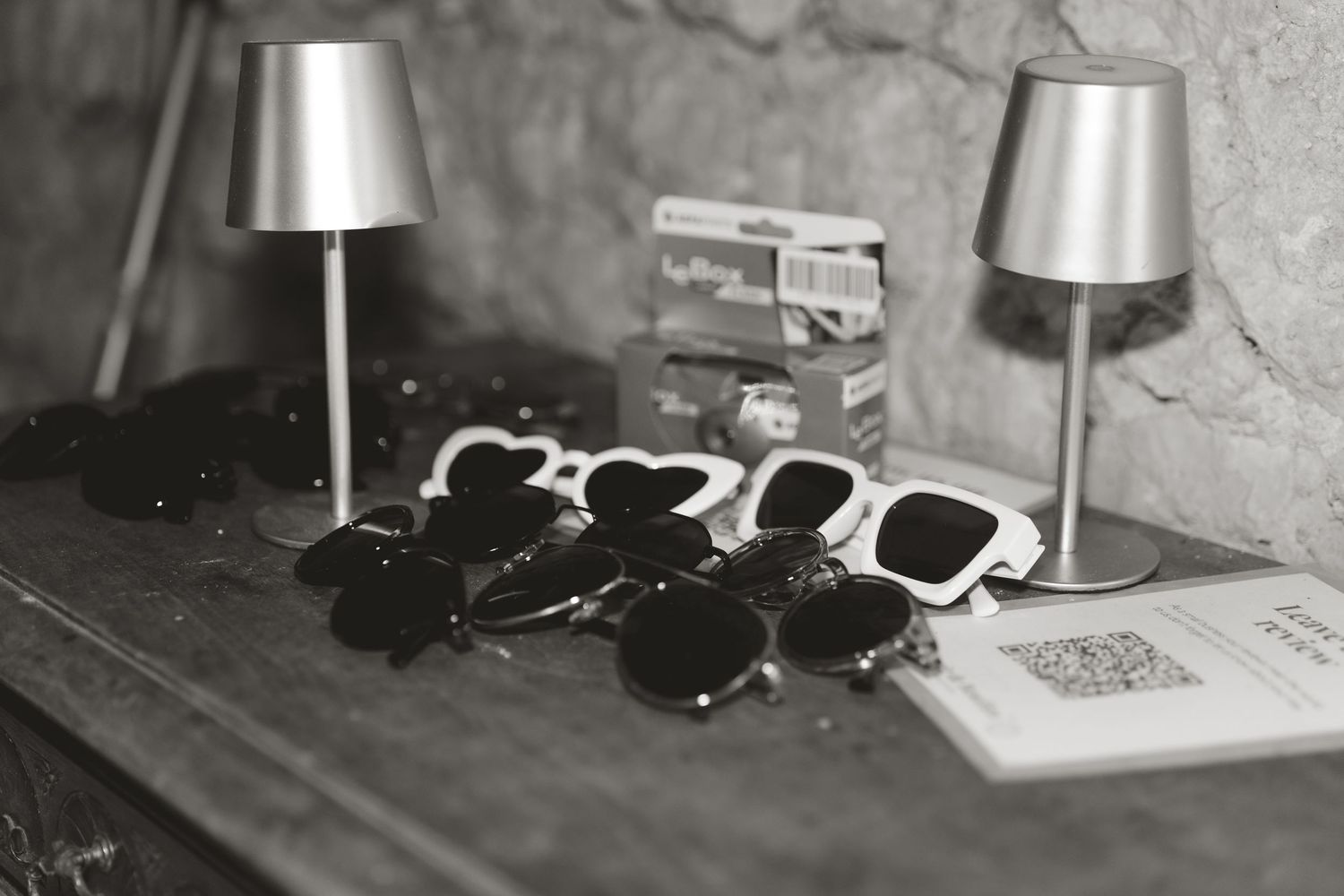 Collection of table decor items including silver lamps and sunglasses at a wedding reception.