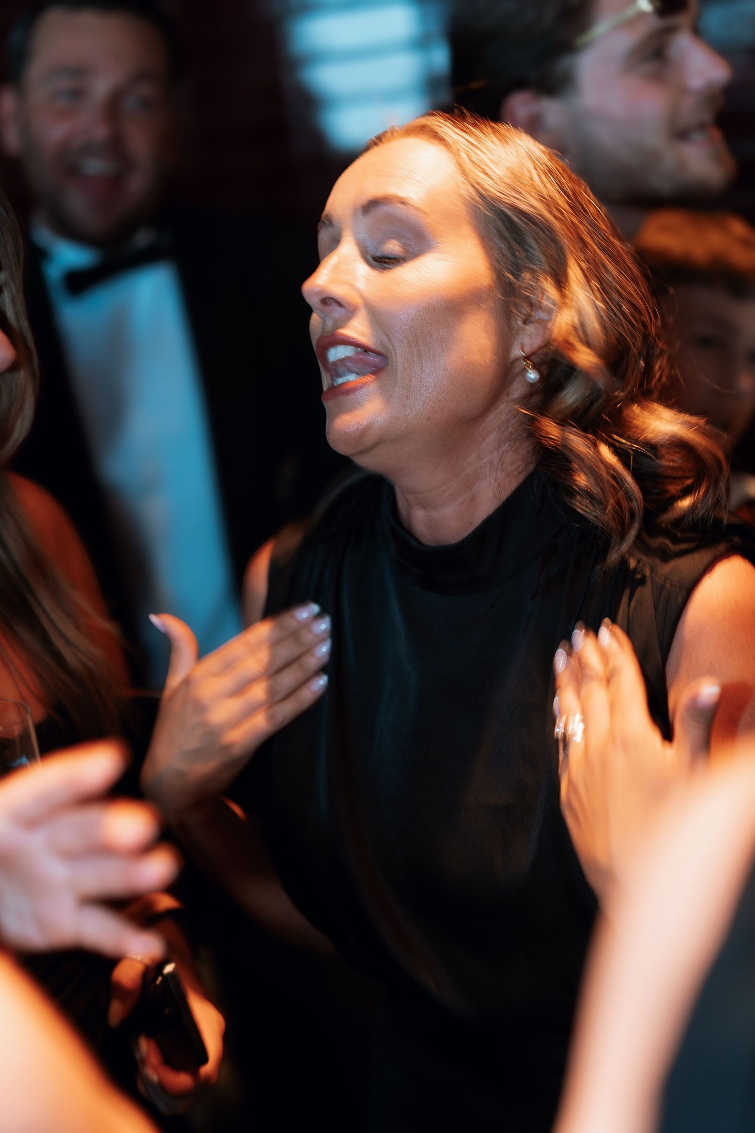 Atmospheric low-light photo sequence capturing joyful expressions during an evening celebration.