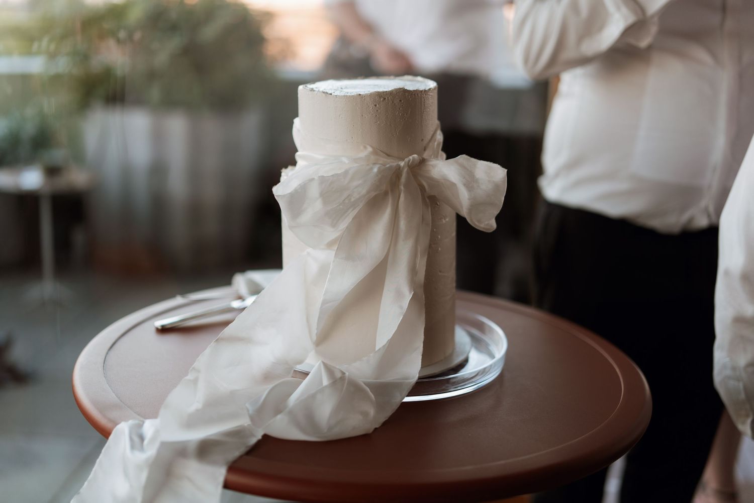 Elegant white napkins arranged on dark wooden tables at a wedding reception.