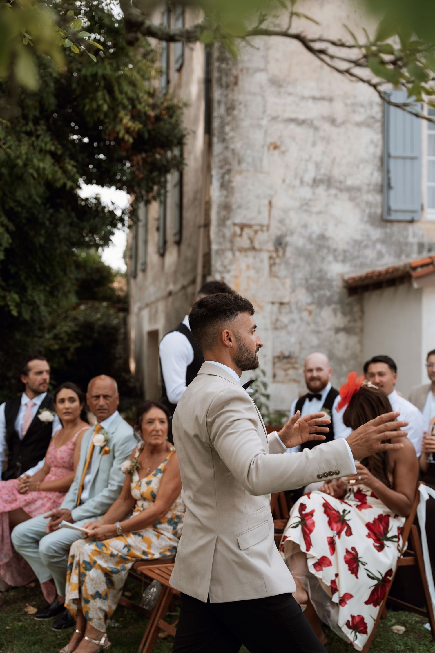 Wedding guests seated outdoors enjoying casual reception at stone venue.