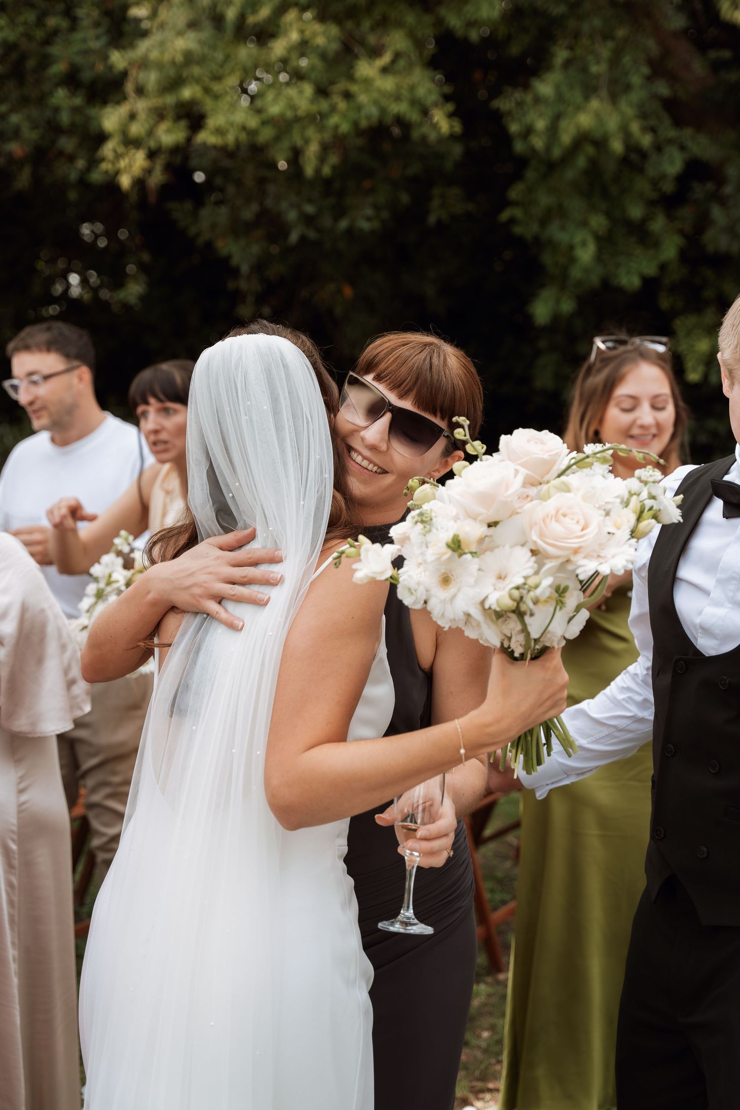 Wedding guests celebrate with champagne toasts during an outdoor reception.
