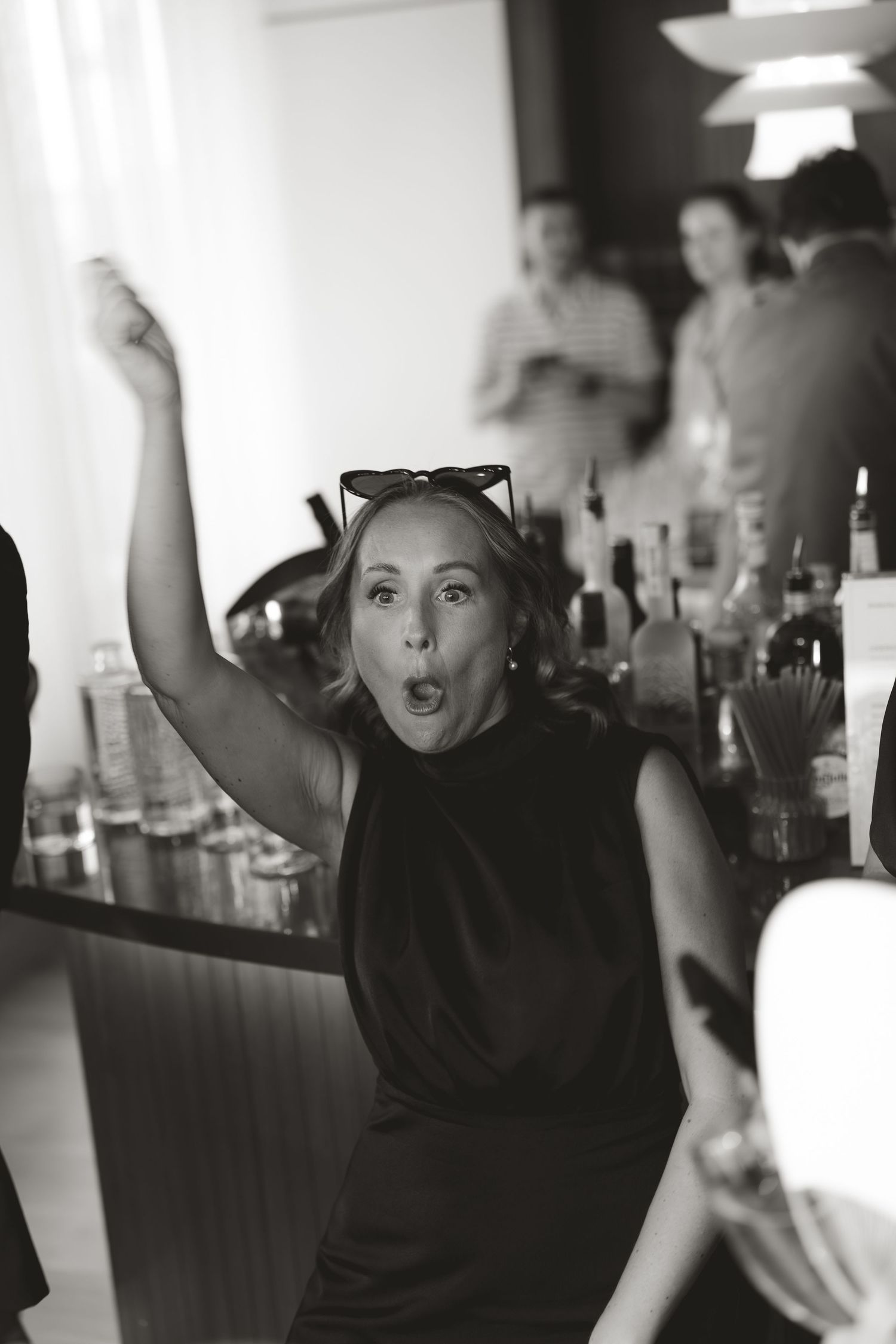 Black and white photo of someone dancing energetically at a celebration.