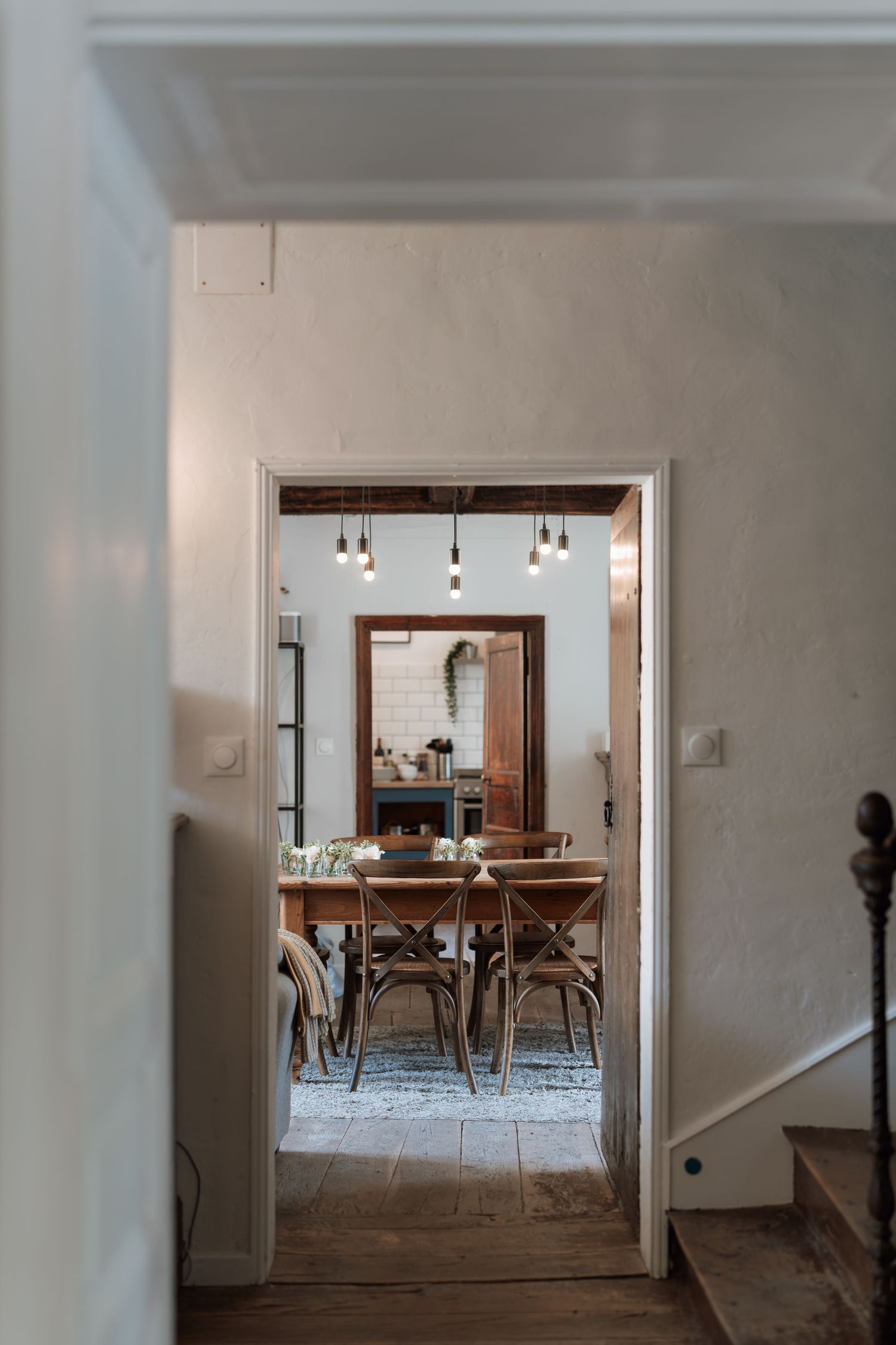 Interior hallway view showing a series of doorways leading to a dining room with white walls.