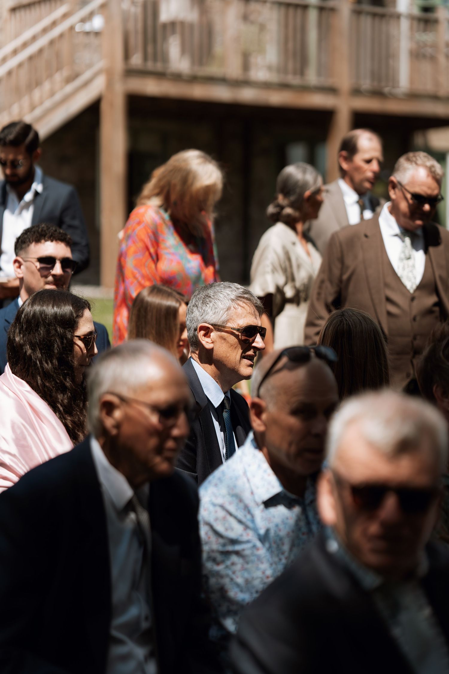 A crowd of formally dressed people gathered at an outdoor event.