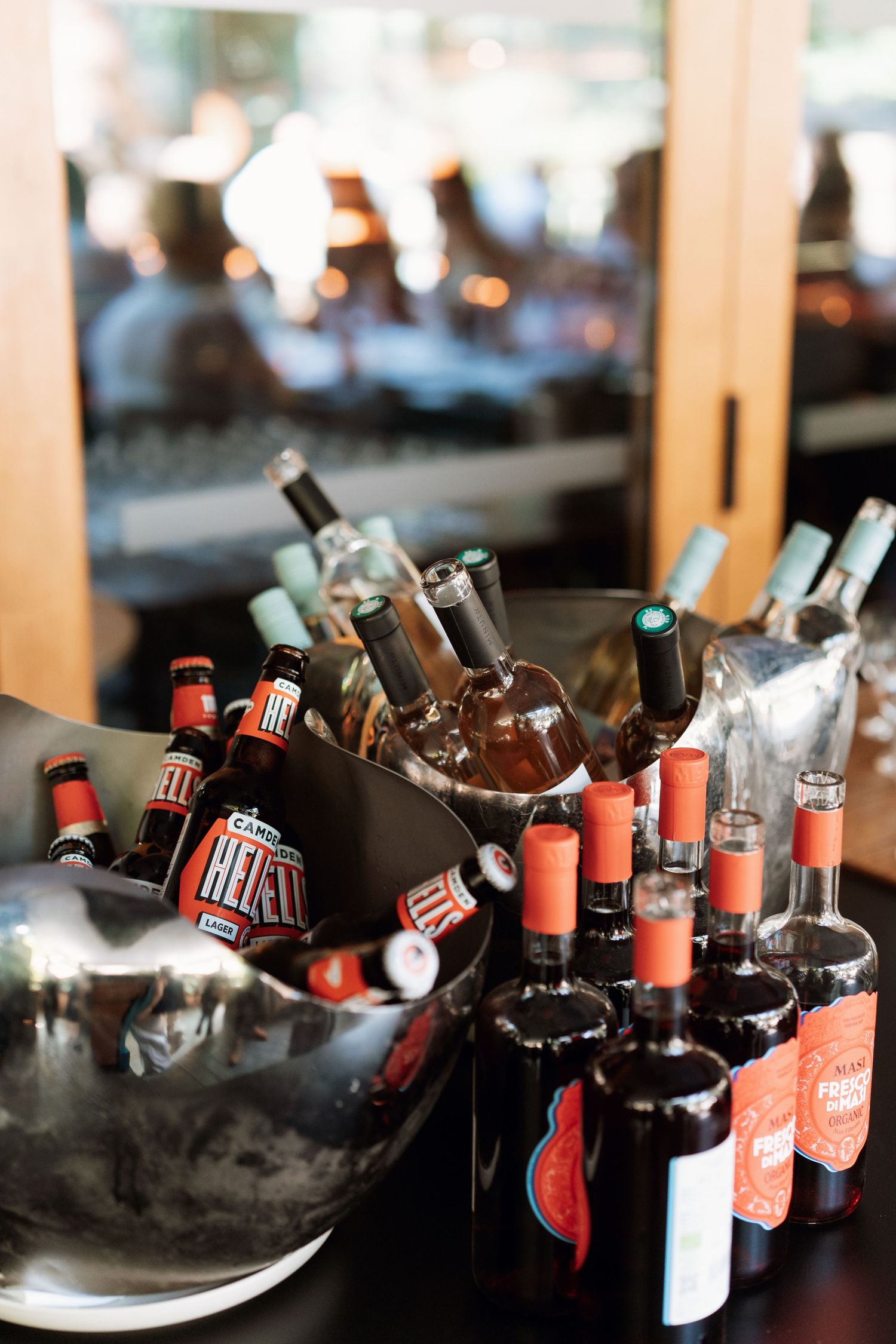 Collection of beer bottles chilling in ice buckets at a reception.