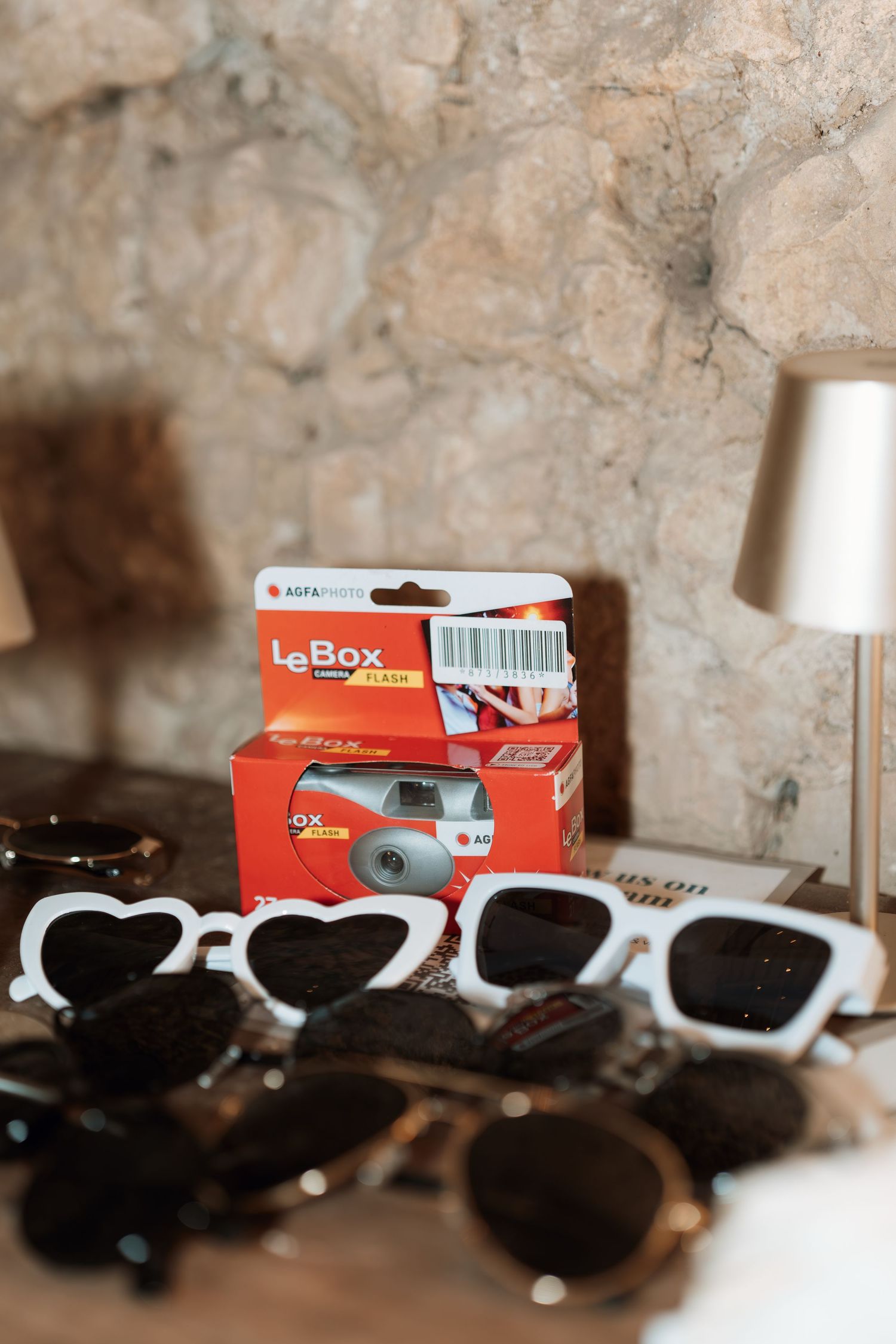 Collection of white sunglasses and LaBoss packaging displayed on a textured surface.
