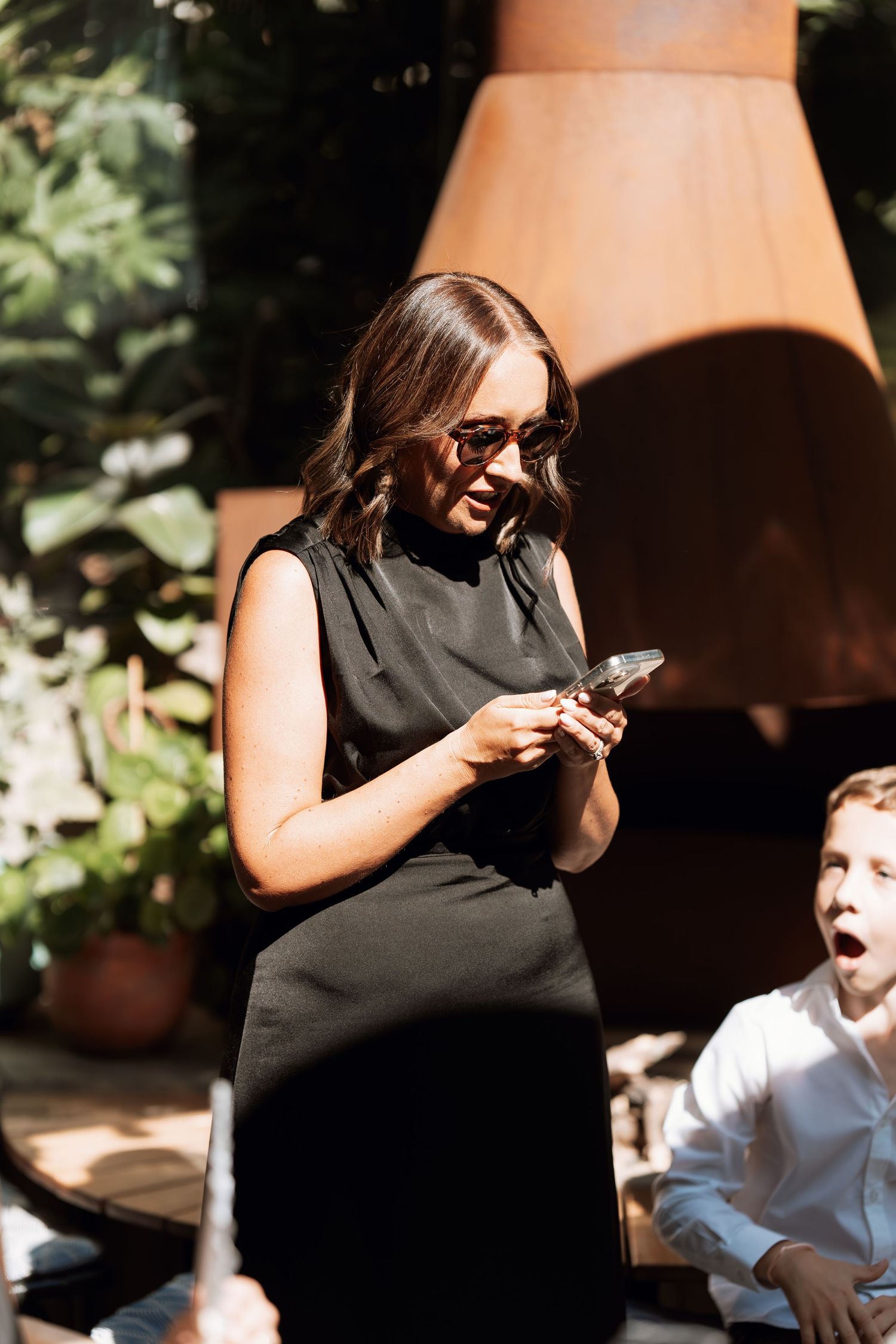 A sequence of candid moments showing a person in black raising a glass during what appears to be a celebration.