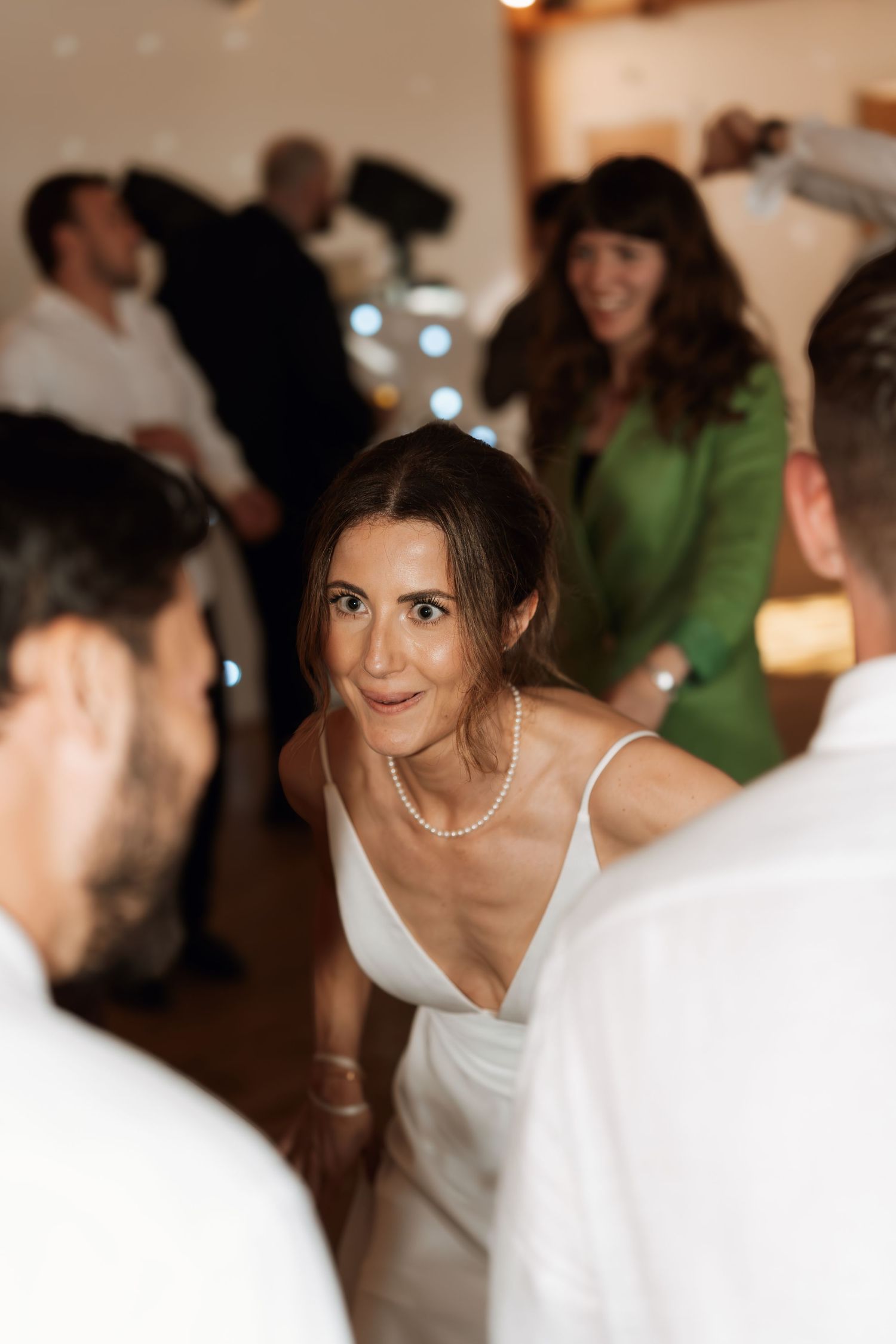 Candid reception moments show guests in white attire celebrating indoors.