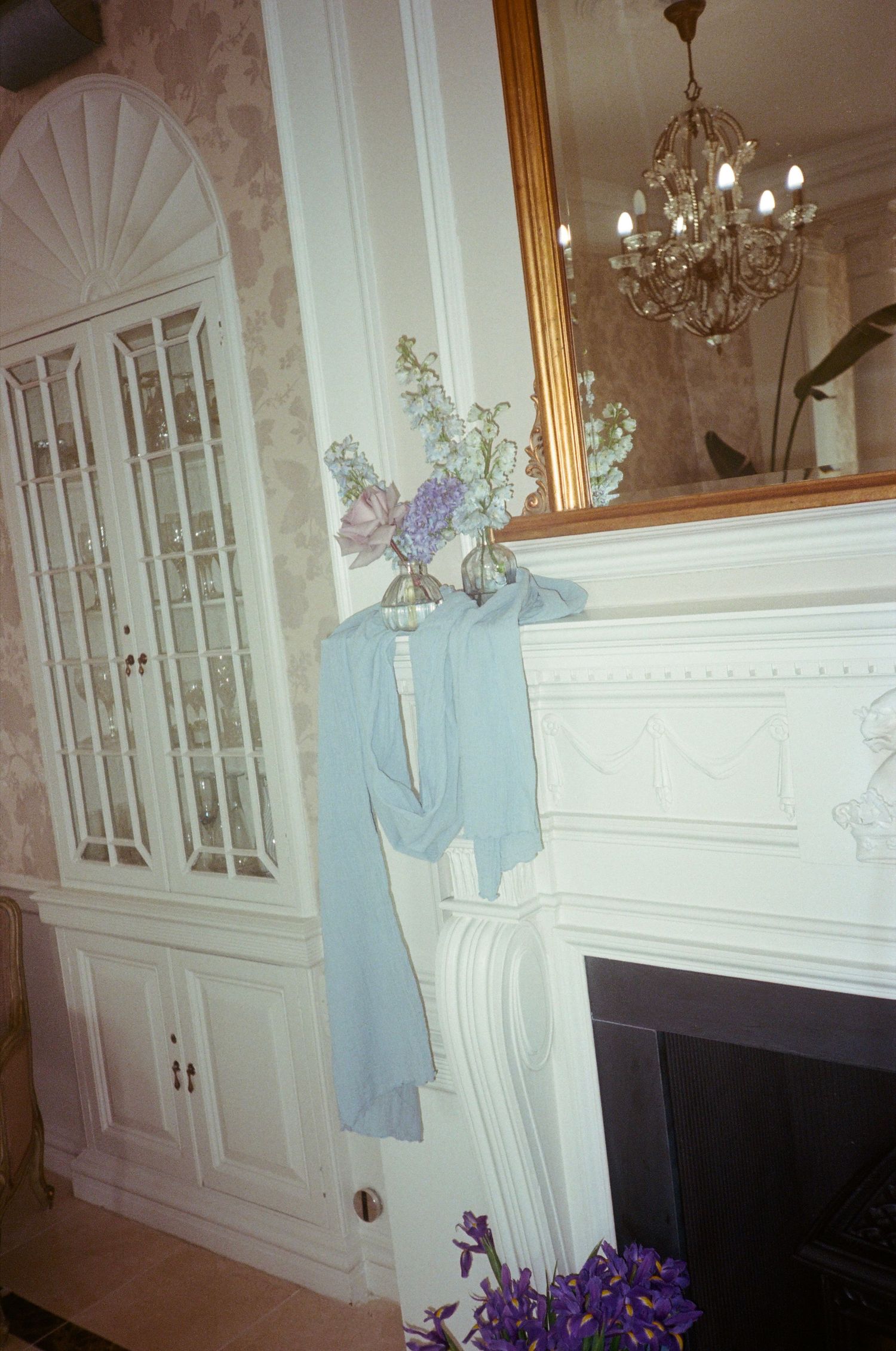 Elegant white paneled walls with decorative molding and crystal chandeliers in a formal room with light blue accents.