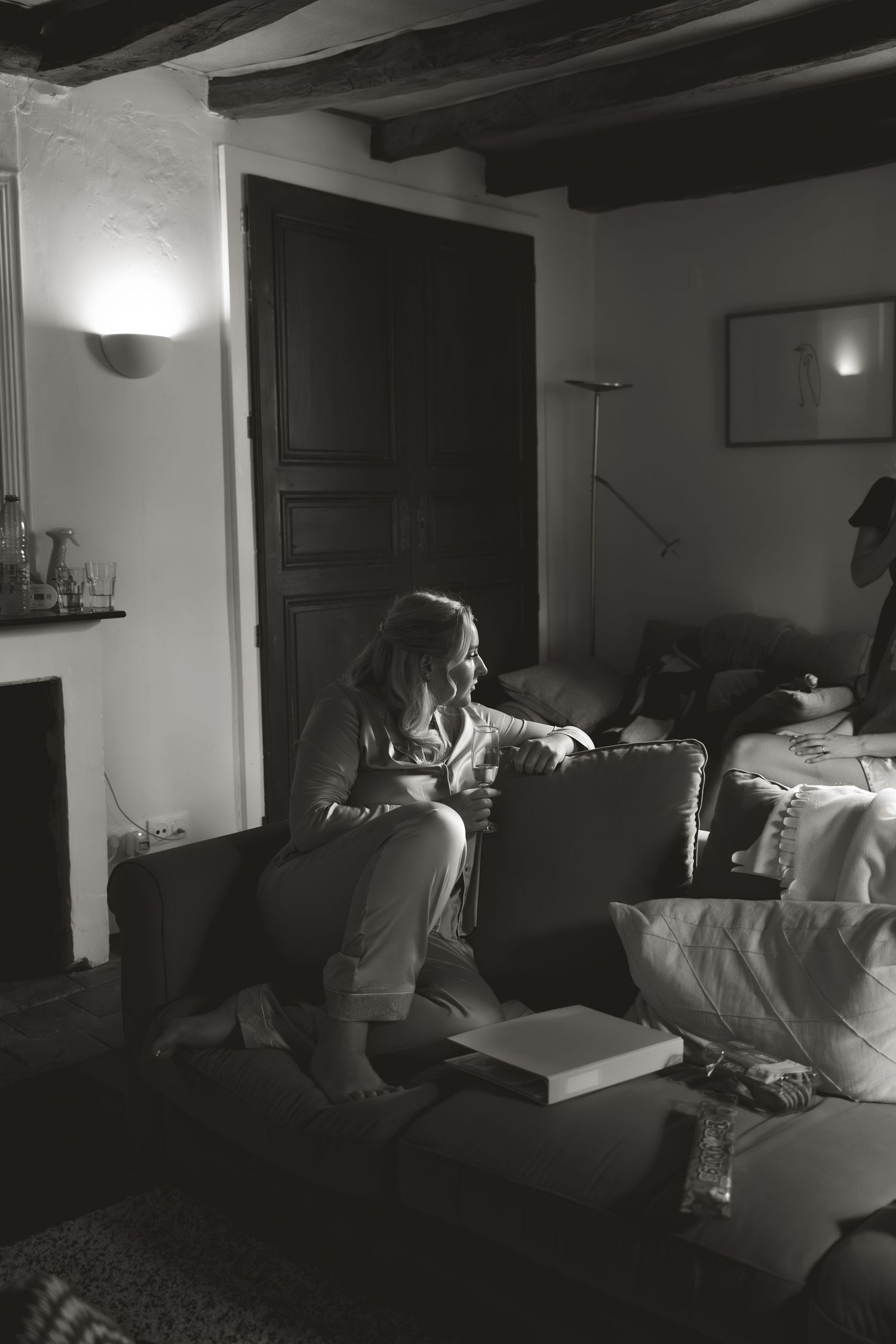A series of dimly lit interior shots showing someone sitting on a couch in low lighting conditions.