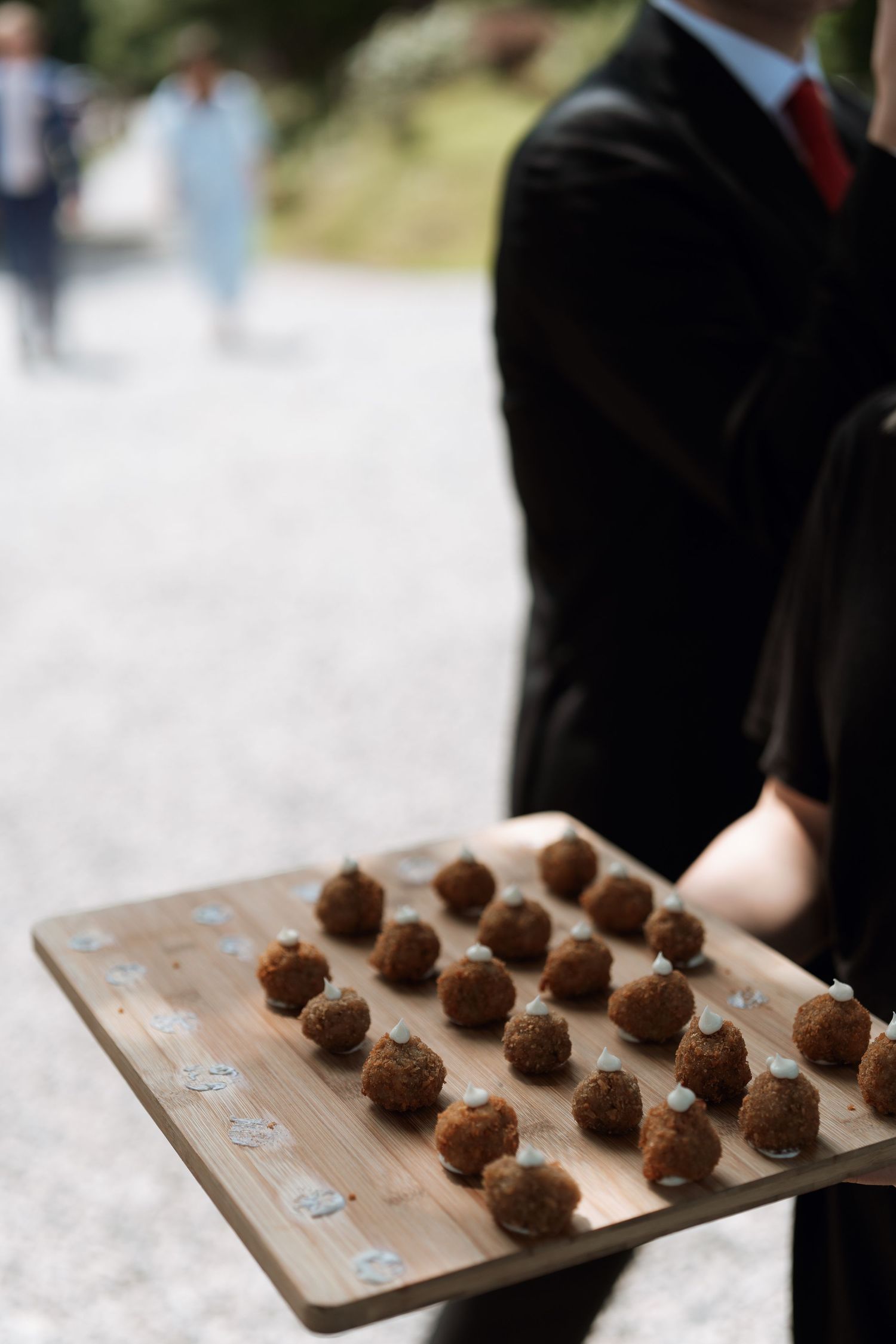 Wooden board displaying neat rows of chocolate truffles at an event.
