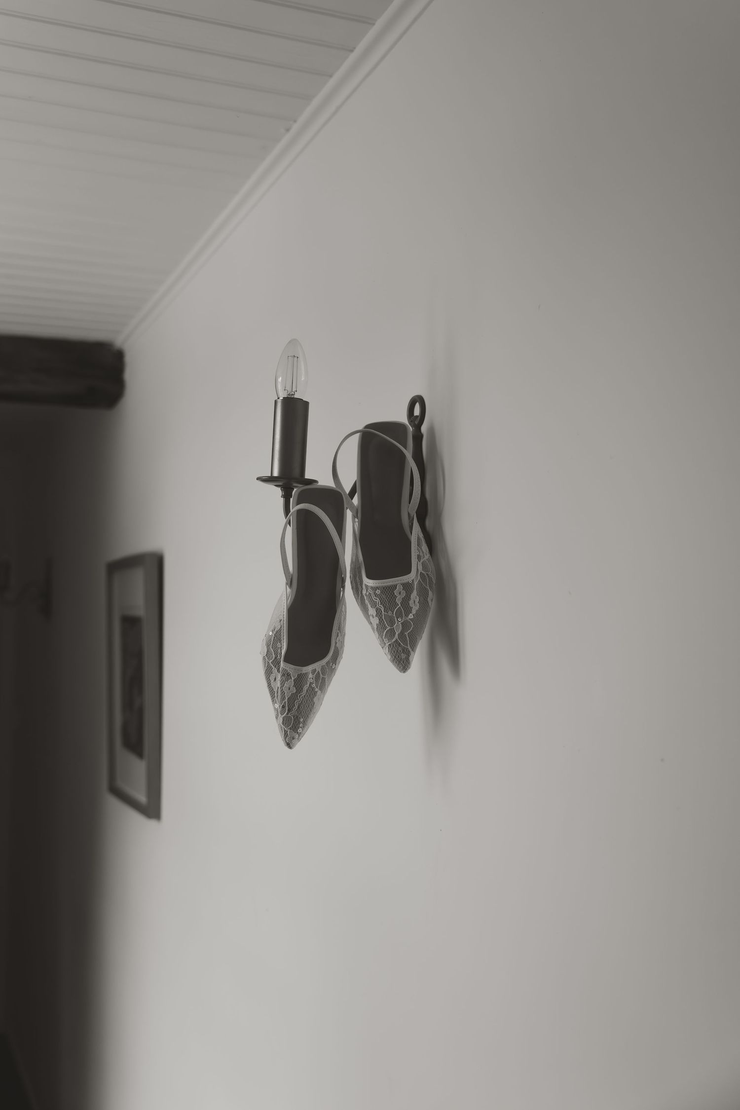 A series of four identical black and white photos showing ballet pointe shoes mounted on a white wall.