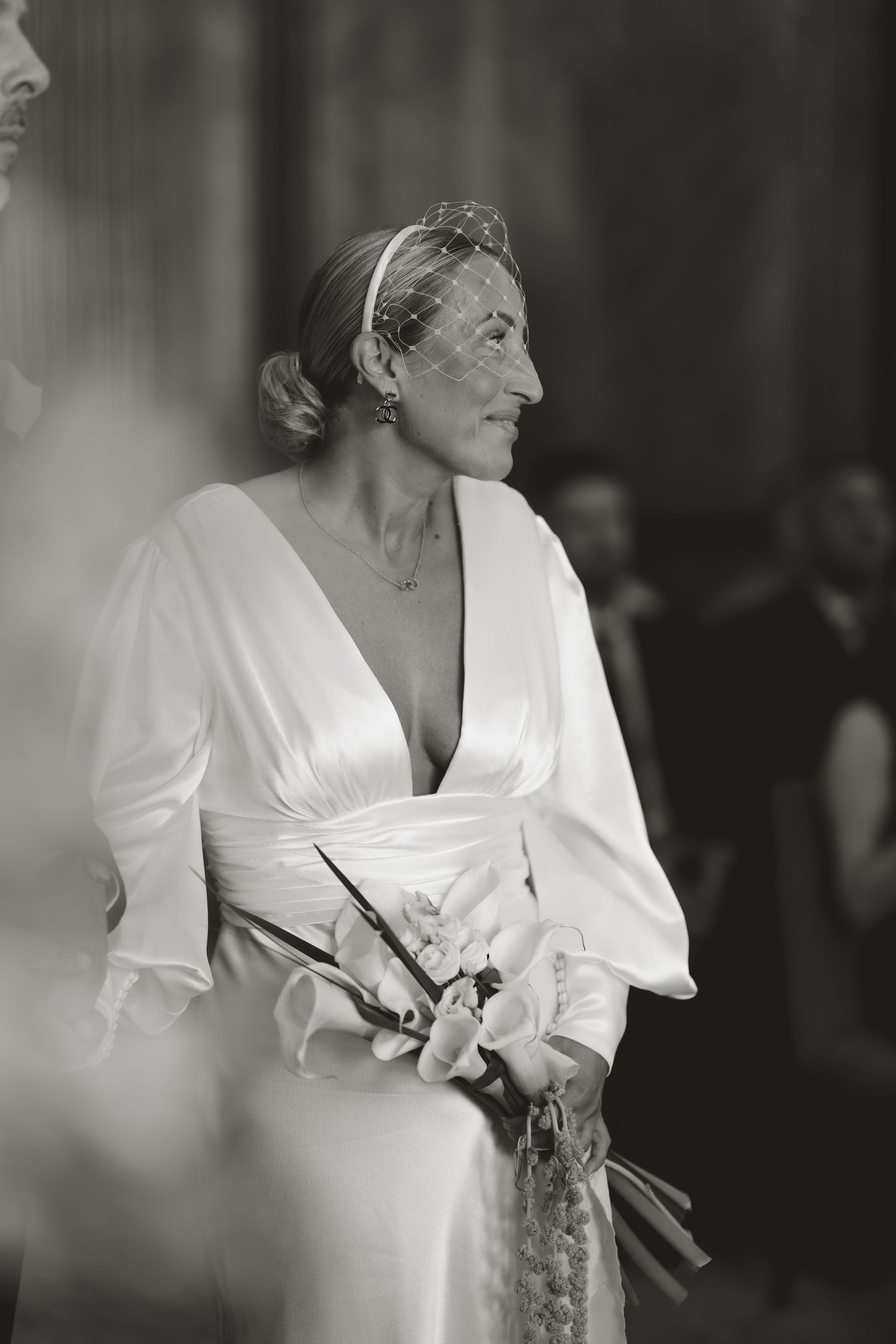 Elegant bride in a white wrap dress with plunging neckline shown in black and white photography.