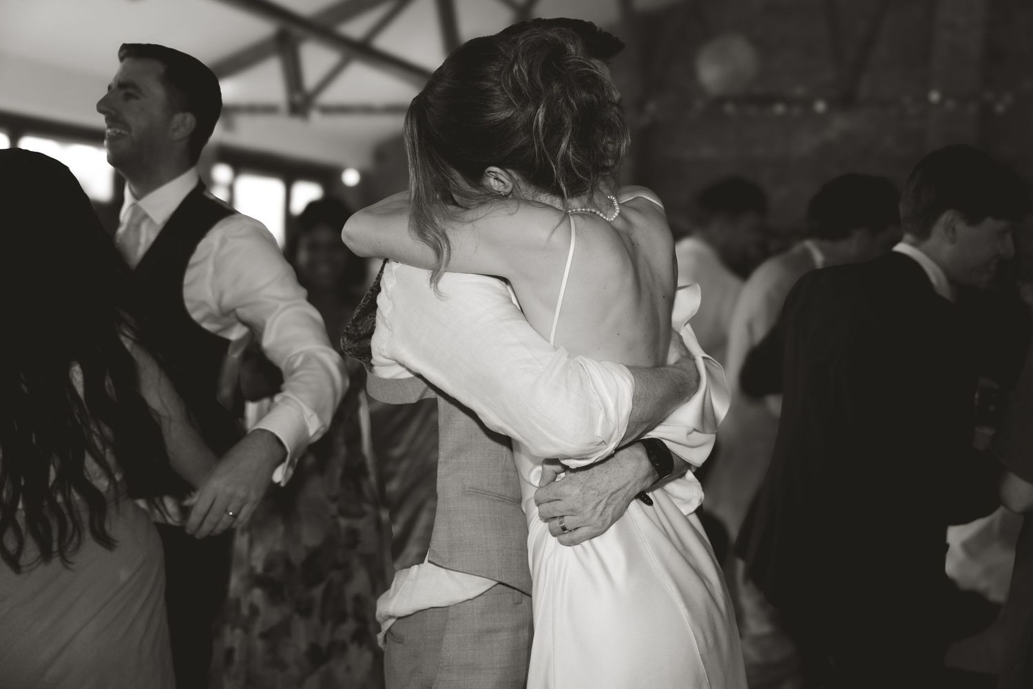 A romantic black and white photo captures an intimate slow dance moment at a wedding reception.