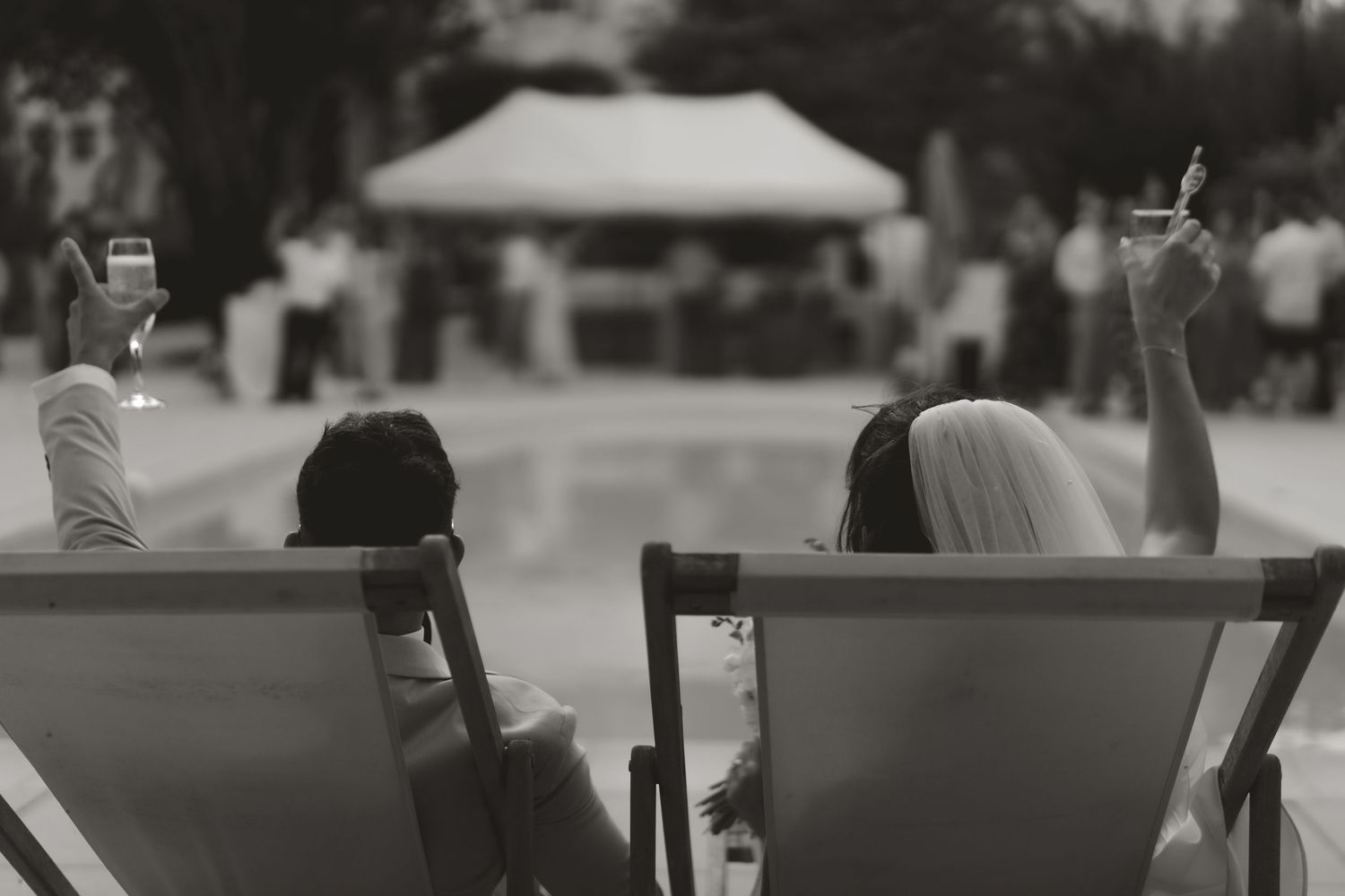 Wedding guests seated at long outdoor tables during elegant garden reception.