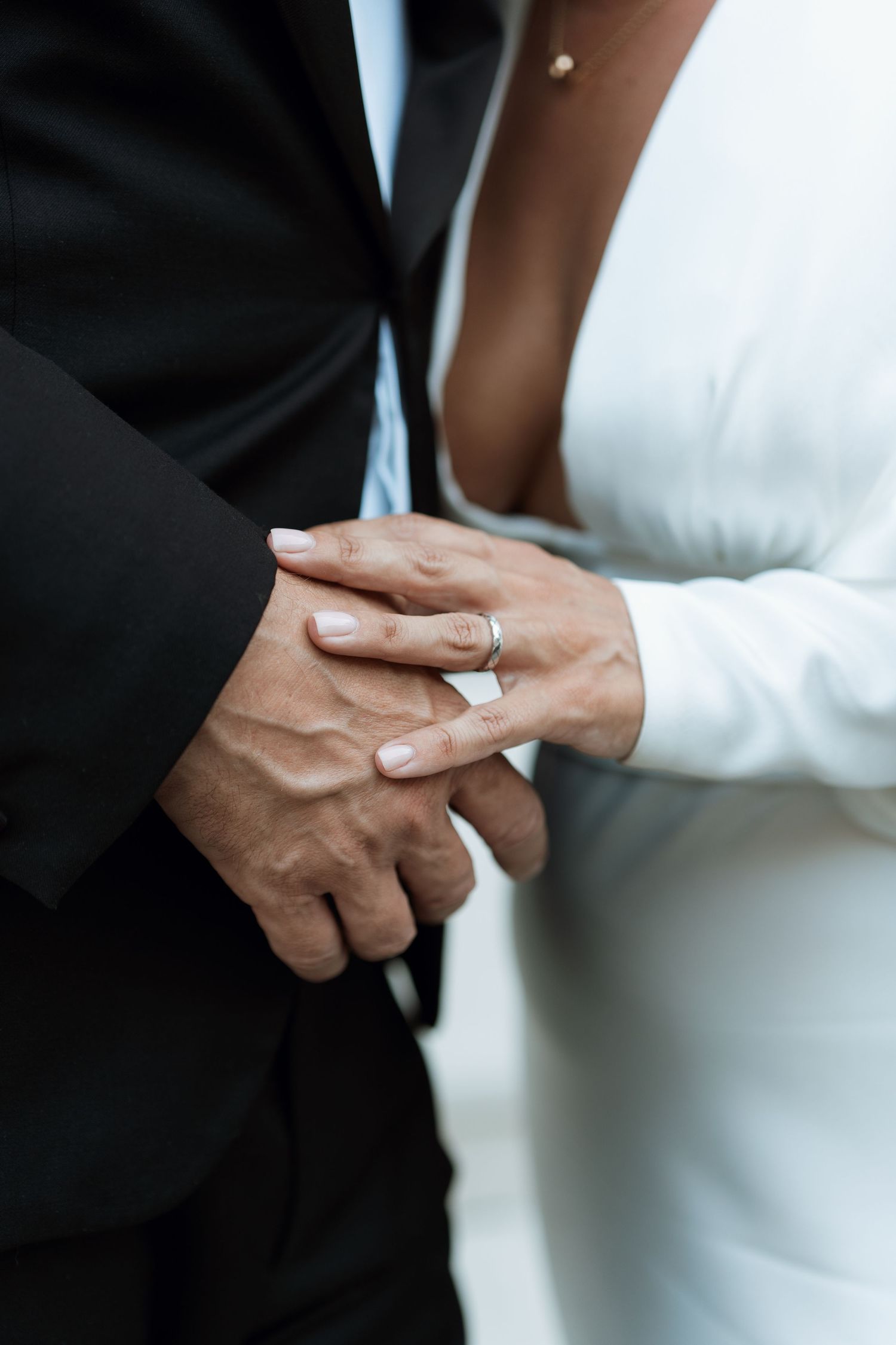 Close-up of hands exchanging rings during a wedding ceremony.