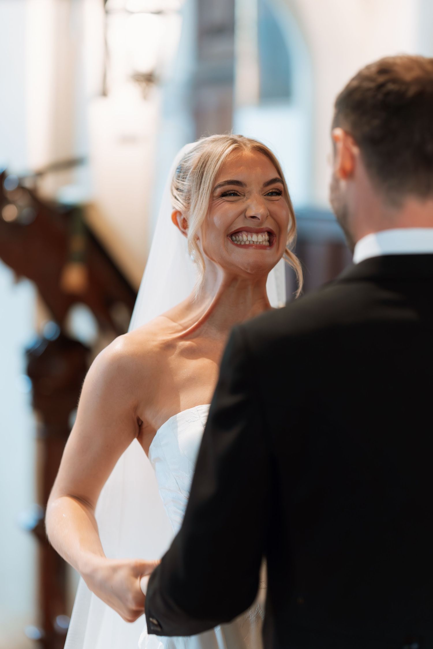A bride and groom share a joyful moment dancing together at their wedding reception.